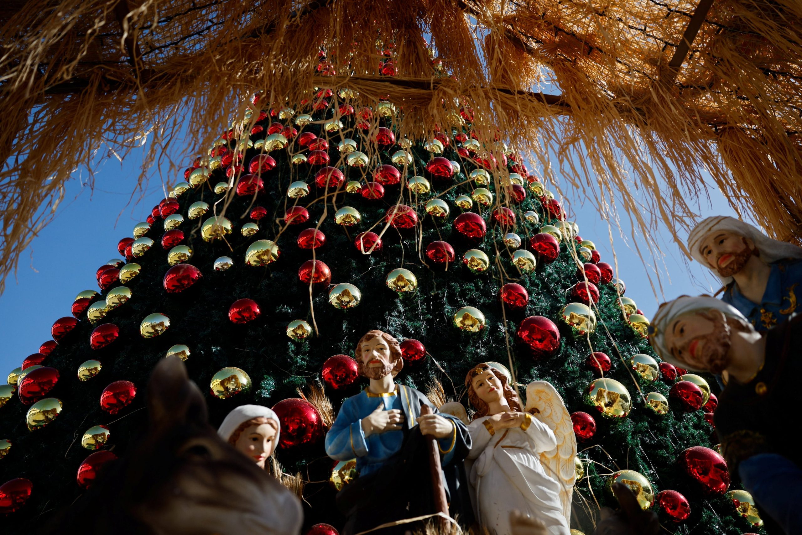 Figuras de la Natividad se encuentran delante del árbol de Navidad, en la Plaza del Pesebre de Belén, en Cisjordania