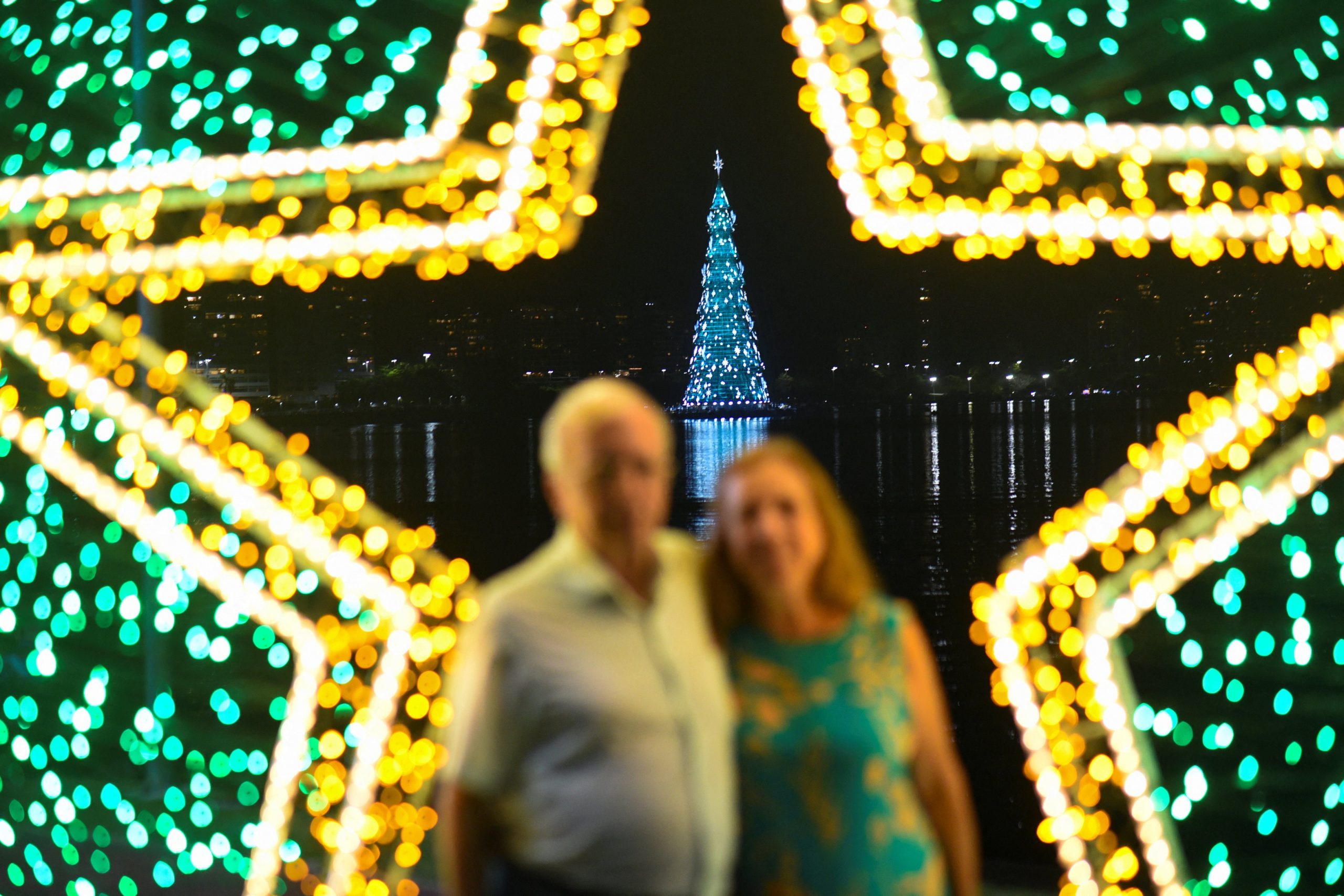 La gente posa para una fotografía durante una ceremonia de iluminación navideña en Río de Janeiro, Brasil.