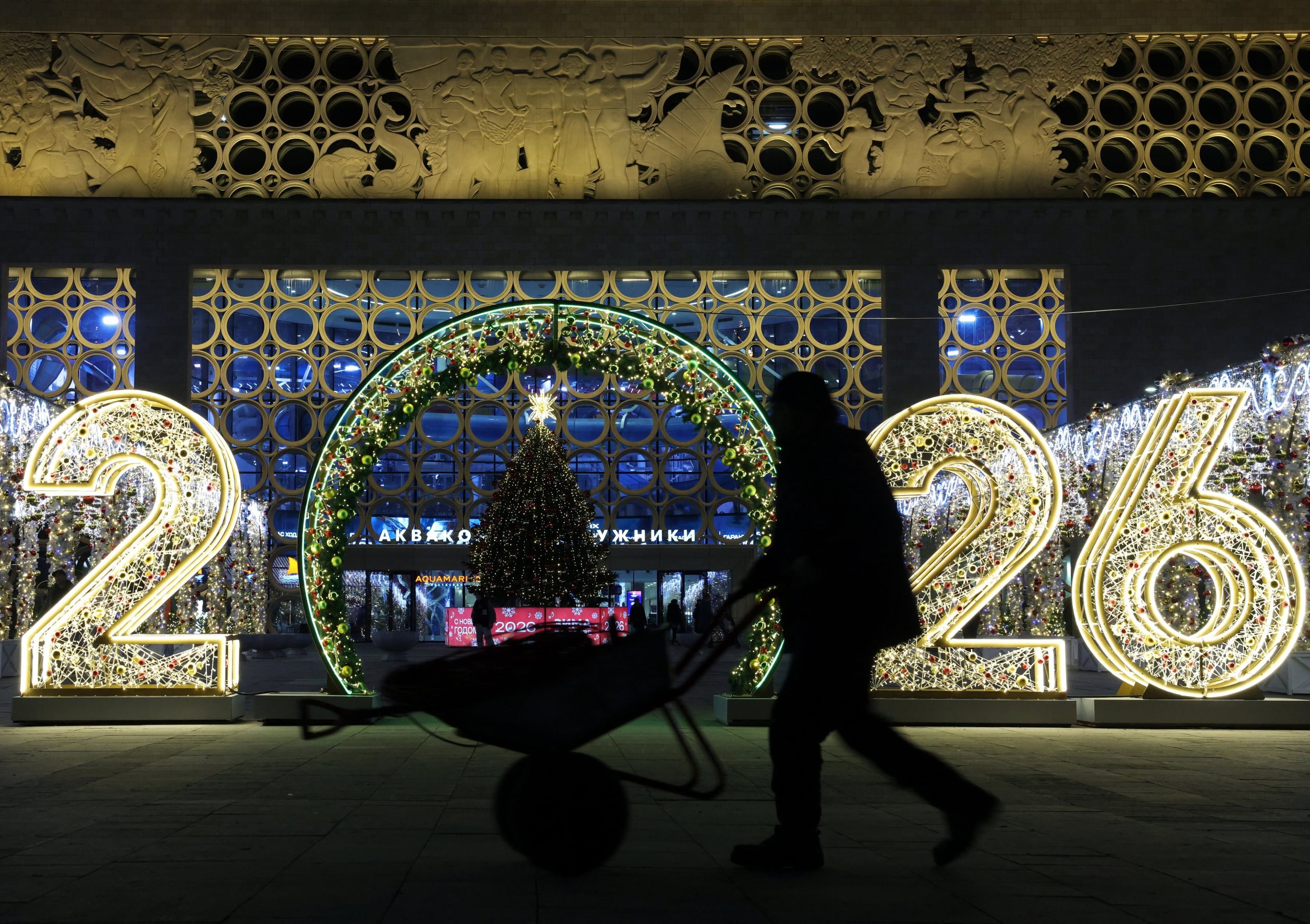 Un trabajador municipal empuja una carretilla entre decoraciones de Año Nuevo y Navidad en Moscú, Rusia.
