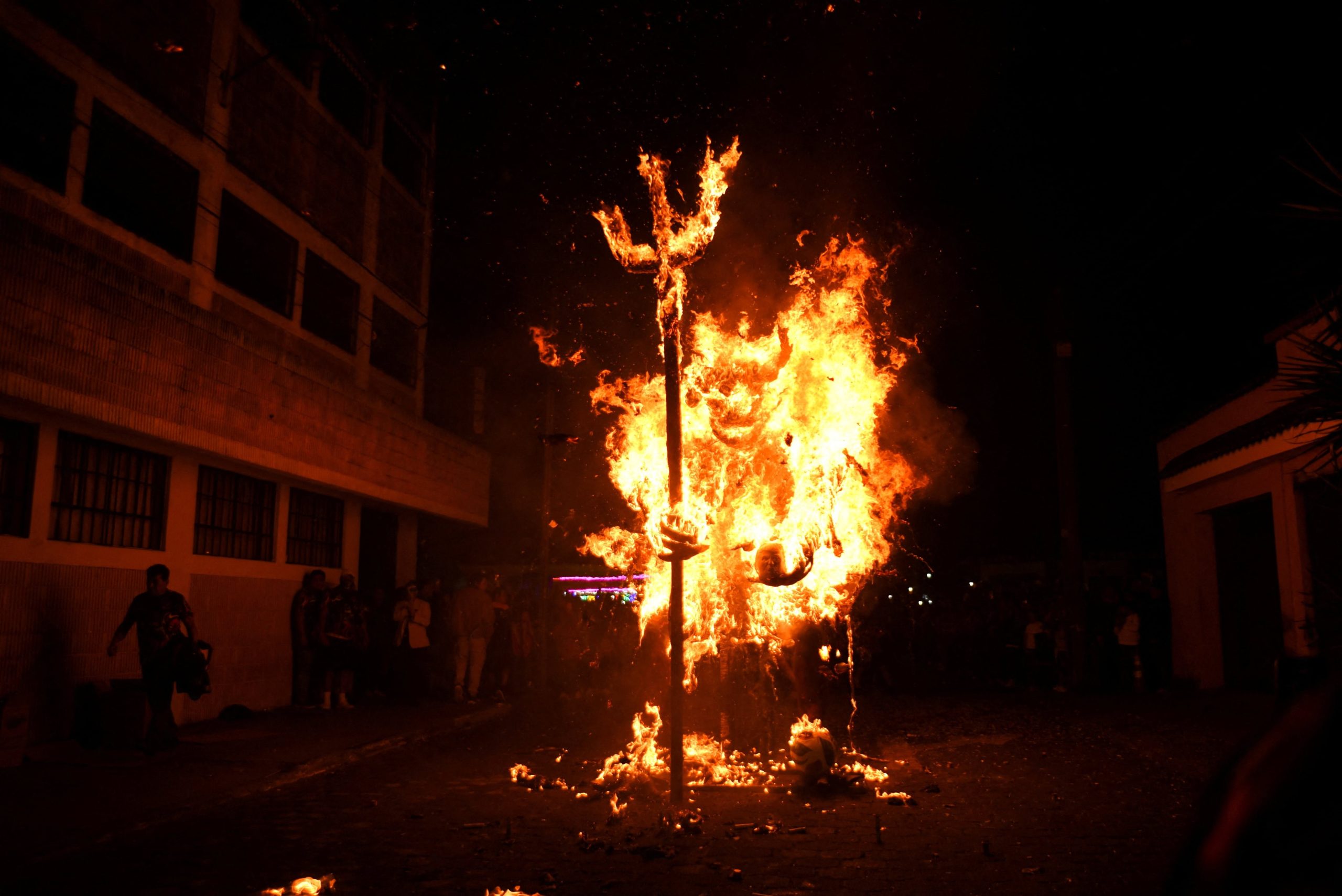 Una figura gigante del diablo sosteniendo una efigie que representa la cabeza del presidente de Estados Unidos, Donald Trump, arde durante la celebración anual de la 'Quema del Diablo', un festival asociado con la Fiesta de la Inmaculada Concepción que honra al santo patrón de la ciudad y marca el comienzo de la temporada navideña, en la Colonia Arrivillaga, Ciudad de Guatemala, Guatemala.