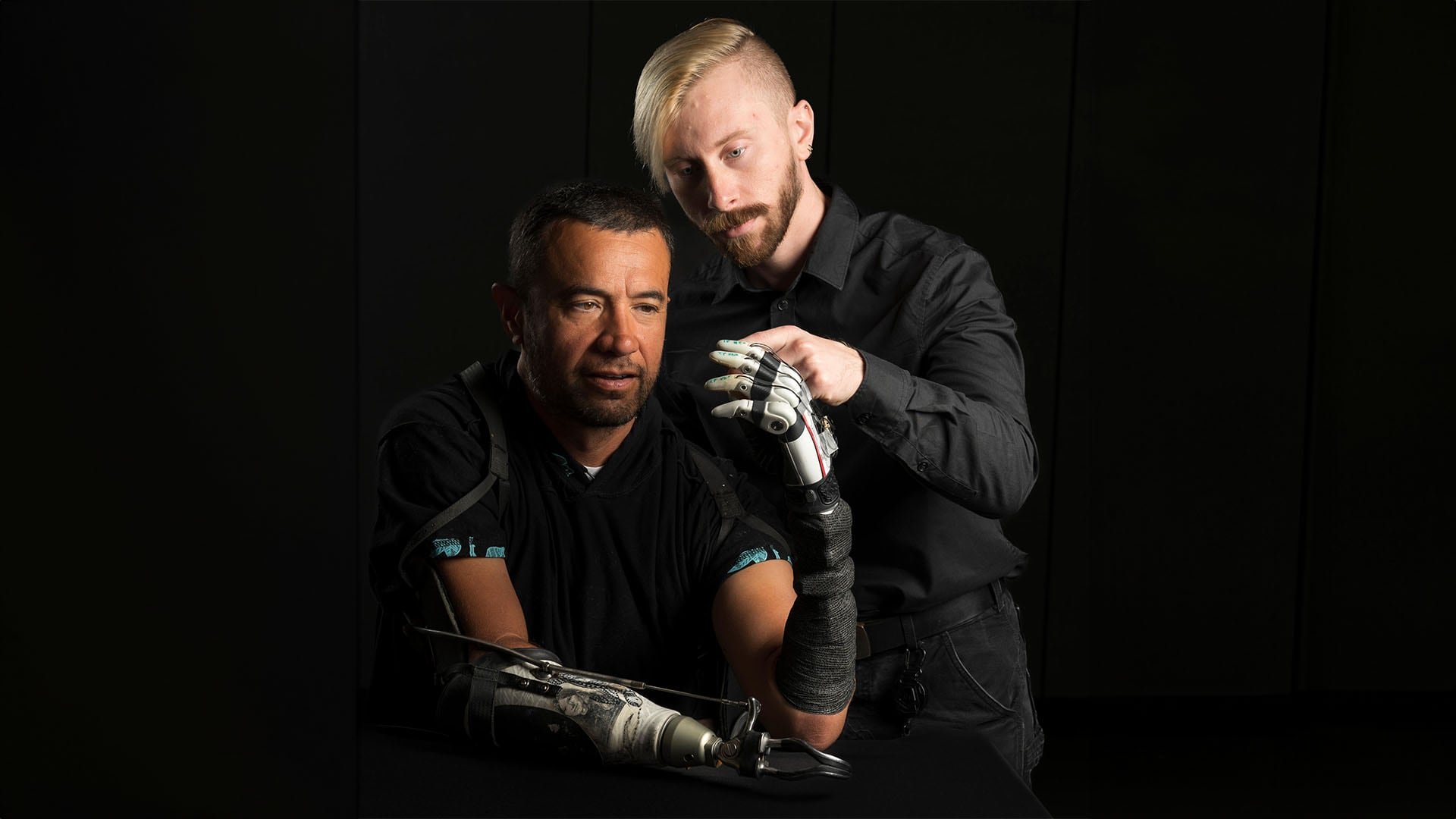 El científico Marshall Trout (a la derecha) con uno de los participantes del ensayo. El control compartido con la mano biónica eleva la tasa de éxito al manipular objetos delicados del 59% al 89% (Utah Neurorobotics Lab)