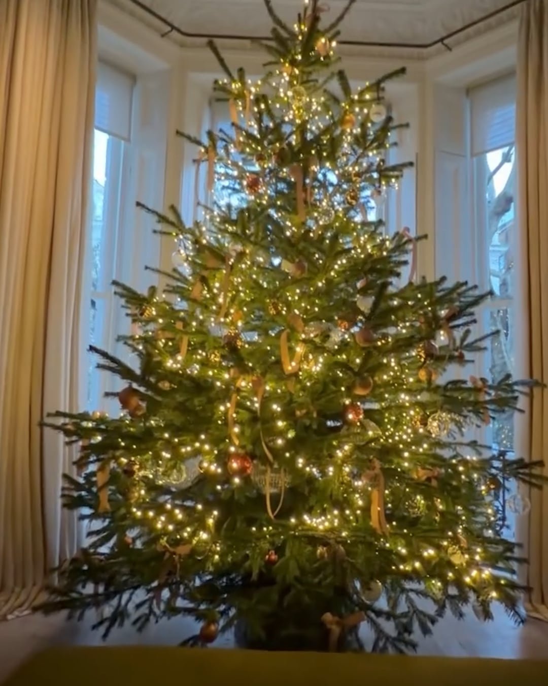 Un conjunto dorado y minimalista define el árbol de la familia Beckham, donde la simpleza de materiales y la disposición espaciada de los adornos realzan la elegancia nórdica 