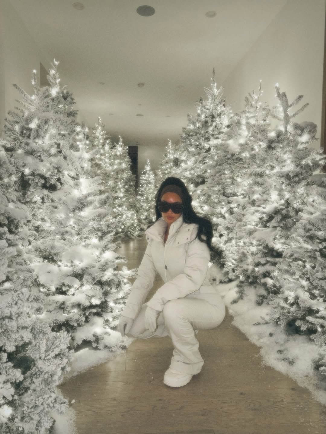Una alineación de múltiples árboles blancos iluminados transforma el espacio de Kim Kardashian en un pasaje invernal de estilo moderno y conceptual 