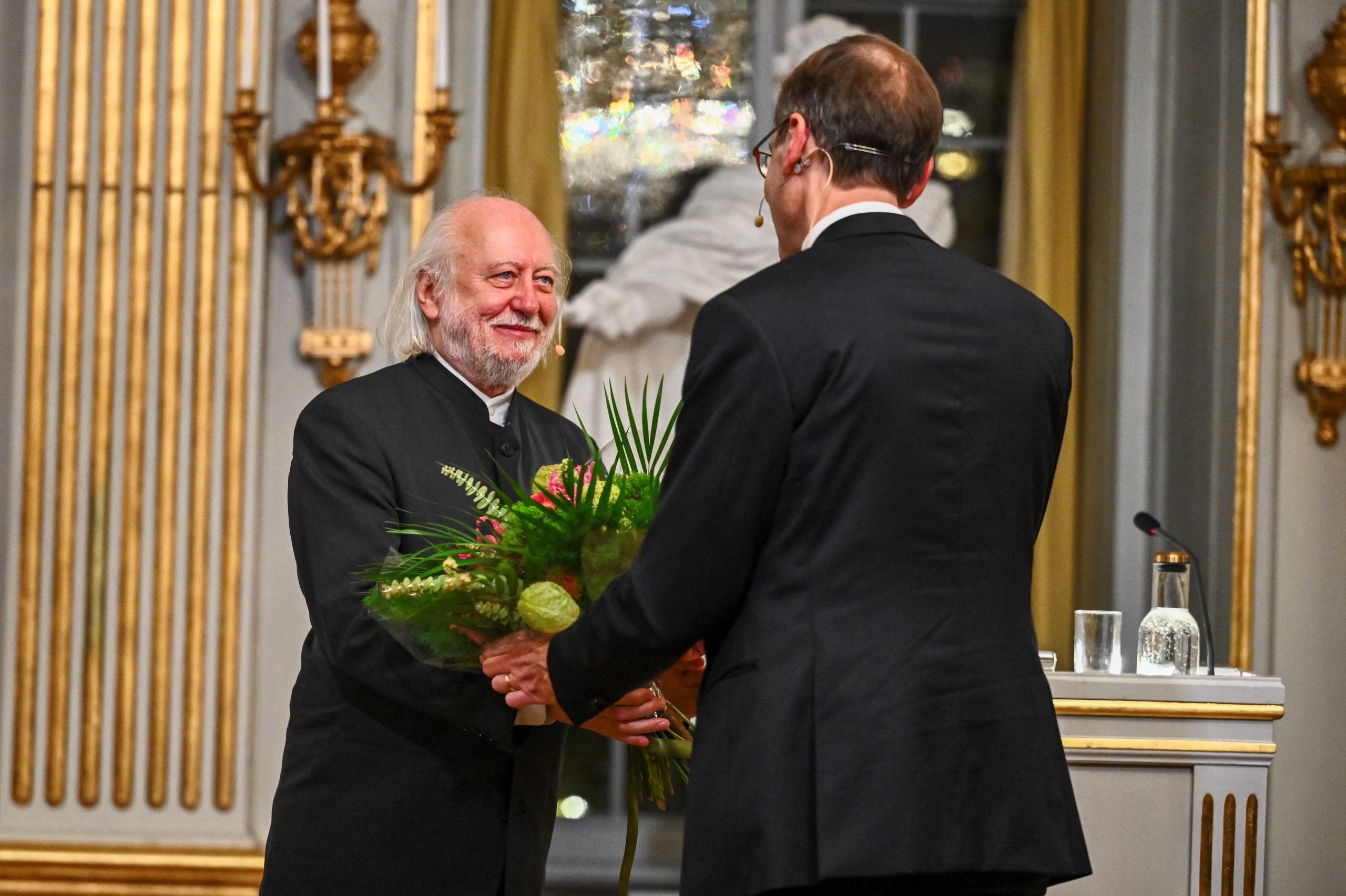 Lászlo Krasznahorkai recibe flores de Mats Malm, Secretario Permanente de la Academia Sueca.