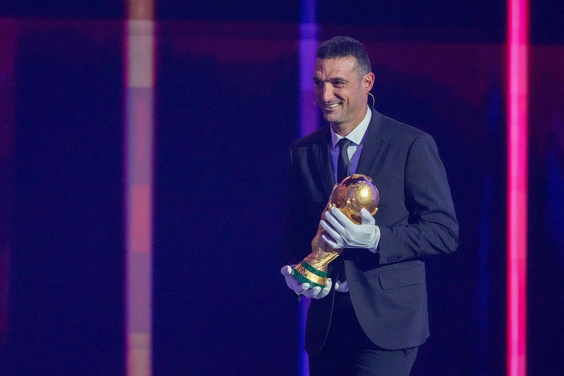 Lionel Scaloni traslada la Copa del Mundo con los guantes blancos en la ceremonia del sorteo de los grupos del Mundial 2026, en Washington DC (Stephanie Scarbrough / POOL / AFP)