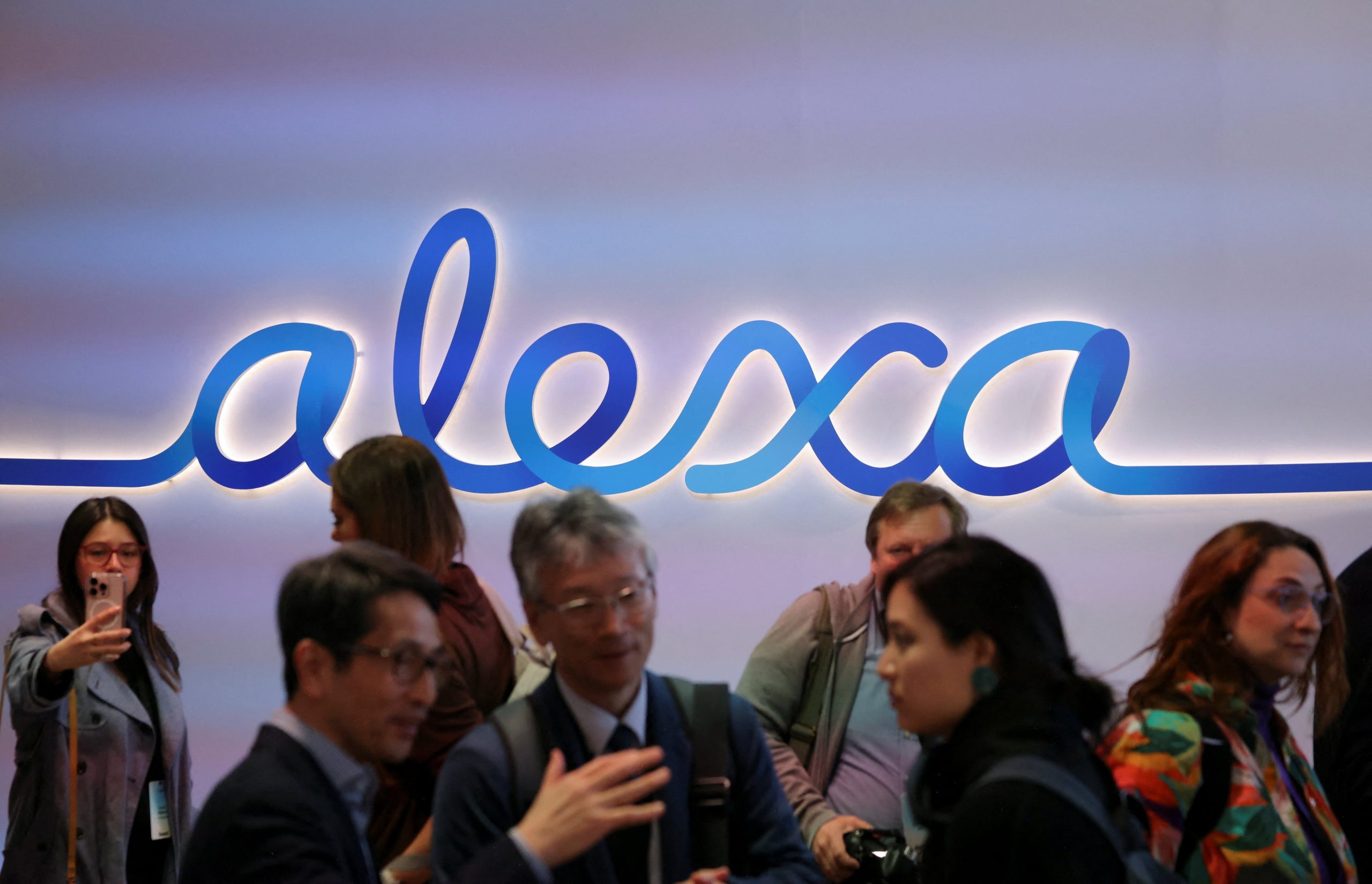 Guests stand in front of a sign that reads 'alexa' during an Amazon Devices launch event in New York City, U.S., February 26, 2025. REUTERS/Brendan McDermid