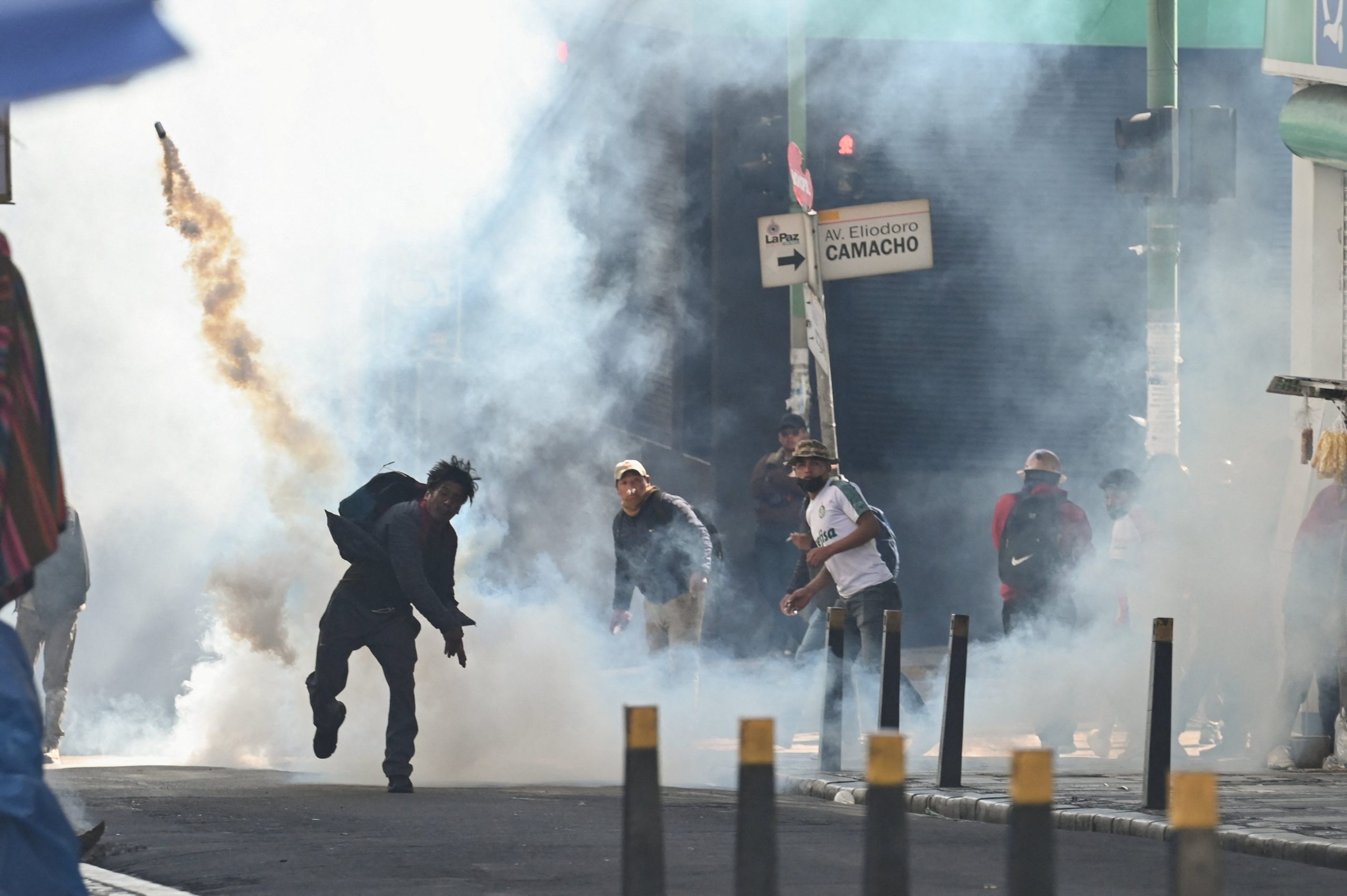 Un hombre lanza un cartucho de gas lacrimógeno mientras mineros afiliados a la Central Obrera Boliviana (COB) se enfrentan con la policía antidisturbios, tras participar en la marcha “Bolivia no está en venta” contra el Decreto 5503 y el aumento de los precios del diésel y la gasolina, en La Paz, Bolivia, el 5 de enero de 2026. (REUTERS/Claudia Morales)