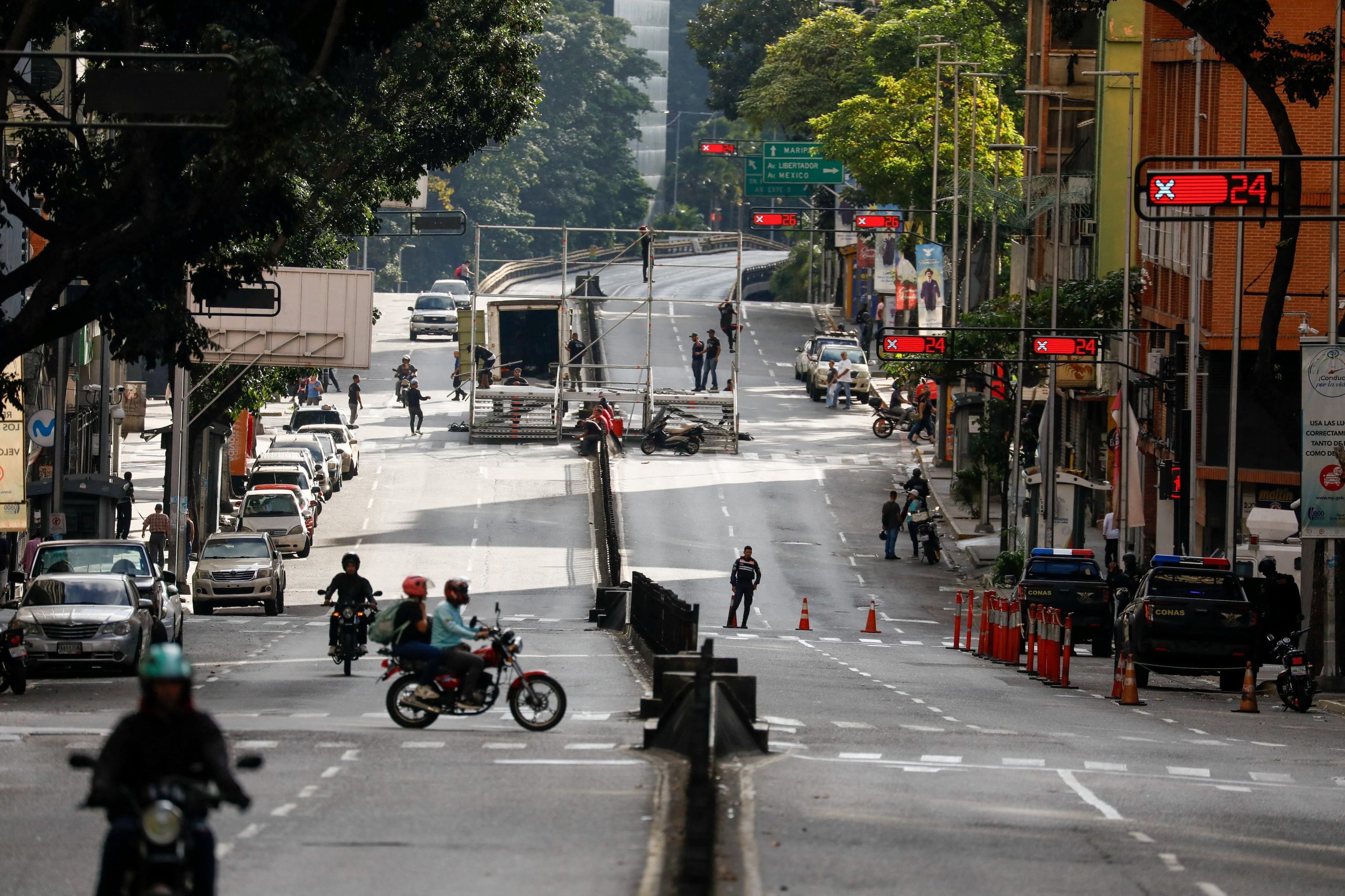 La gente trabaja en una calle, mientras varios barrios permanecen sin electricidad después de que Estados Unidos lanzó un ataque contra Venezuela, capturando a su presidente Nicolás Maduro y su esposa Cilia Flores, en Caracas, Venezuela, el 4 de enero de 2026 (REUTERS/Leonardo Fernández Viloria)