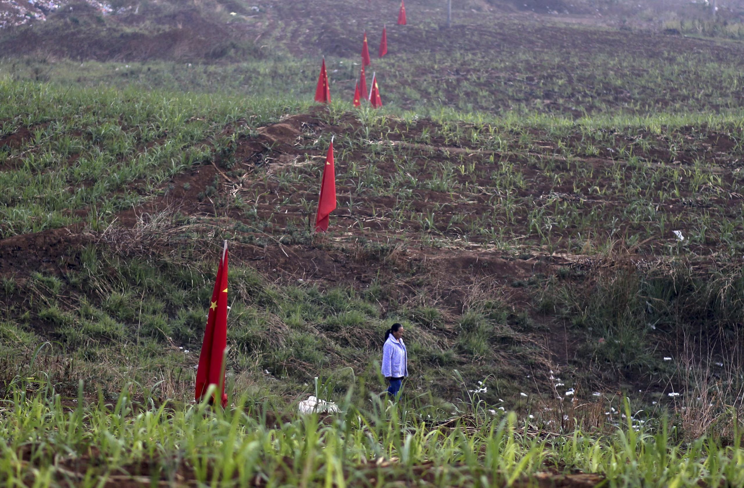 Una mujer camina junto a banderas chinas en Kokang, cerca de la frontera con China. La mayoría de los centros de estafa están dirigidos por organizaciones criminales chinos. (Reuters/archivo)