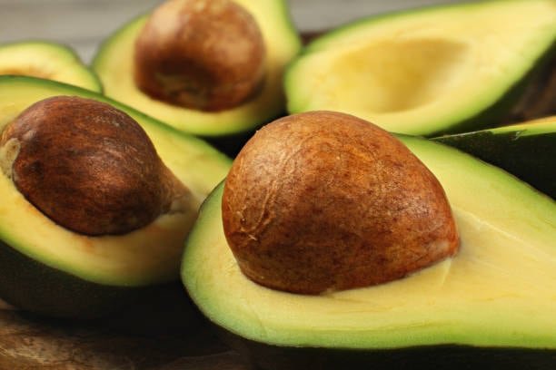 Ingredientes y materiales para preparar una mascarilla de hueso de aguacate para el cabello 
