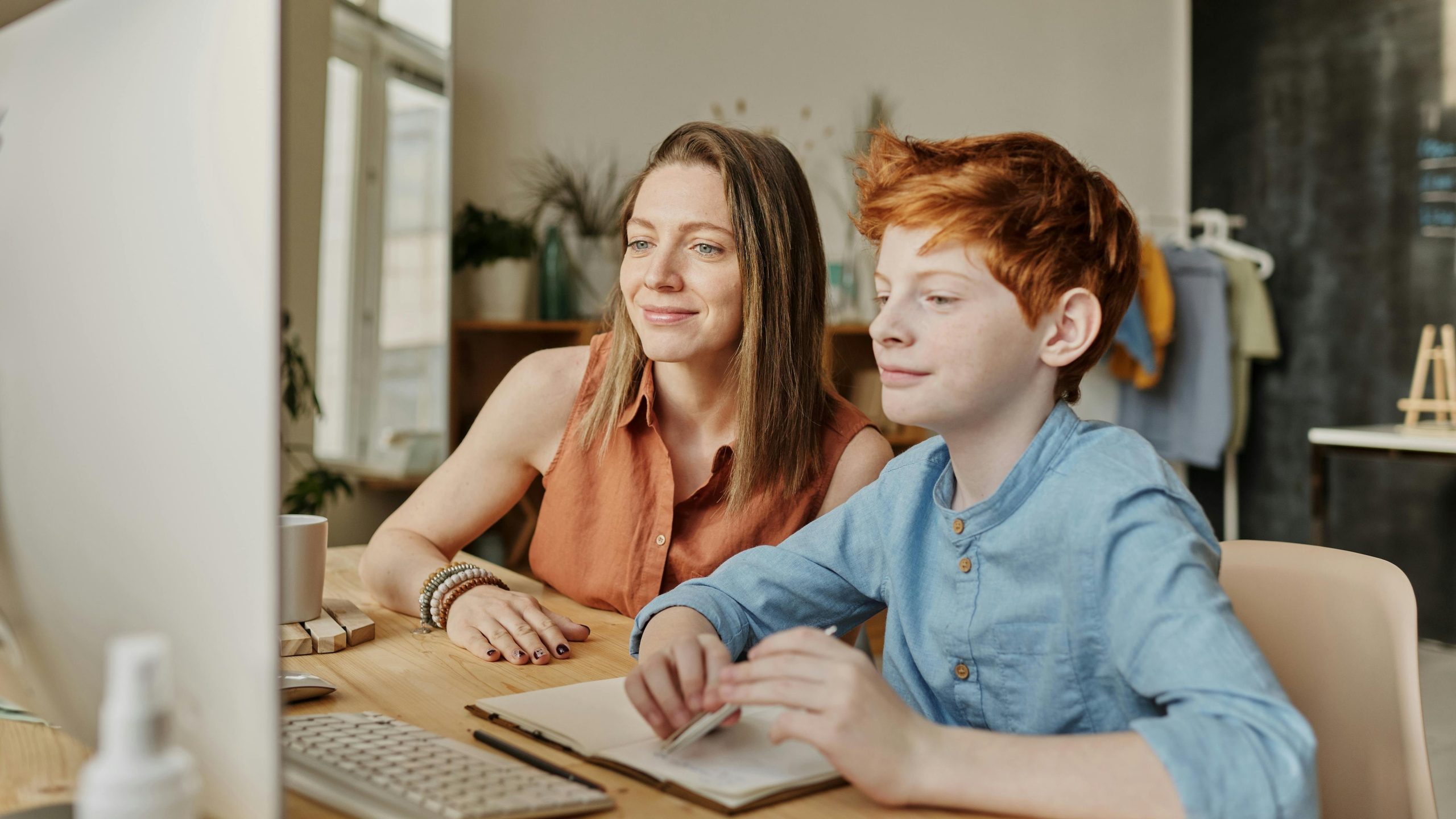 Una madre ayudando a su hijo con la tarea (Pexels)