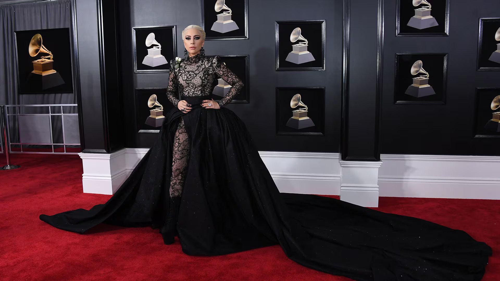 El encaje negro y la sobrefalda monumental de Armani Privé, junto a la rosa blanca, convirtieron a Gaga en símbolo de poder y solidaridad en los Grammy (AFP PHOTO / ANGELA WEISS)