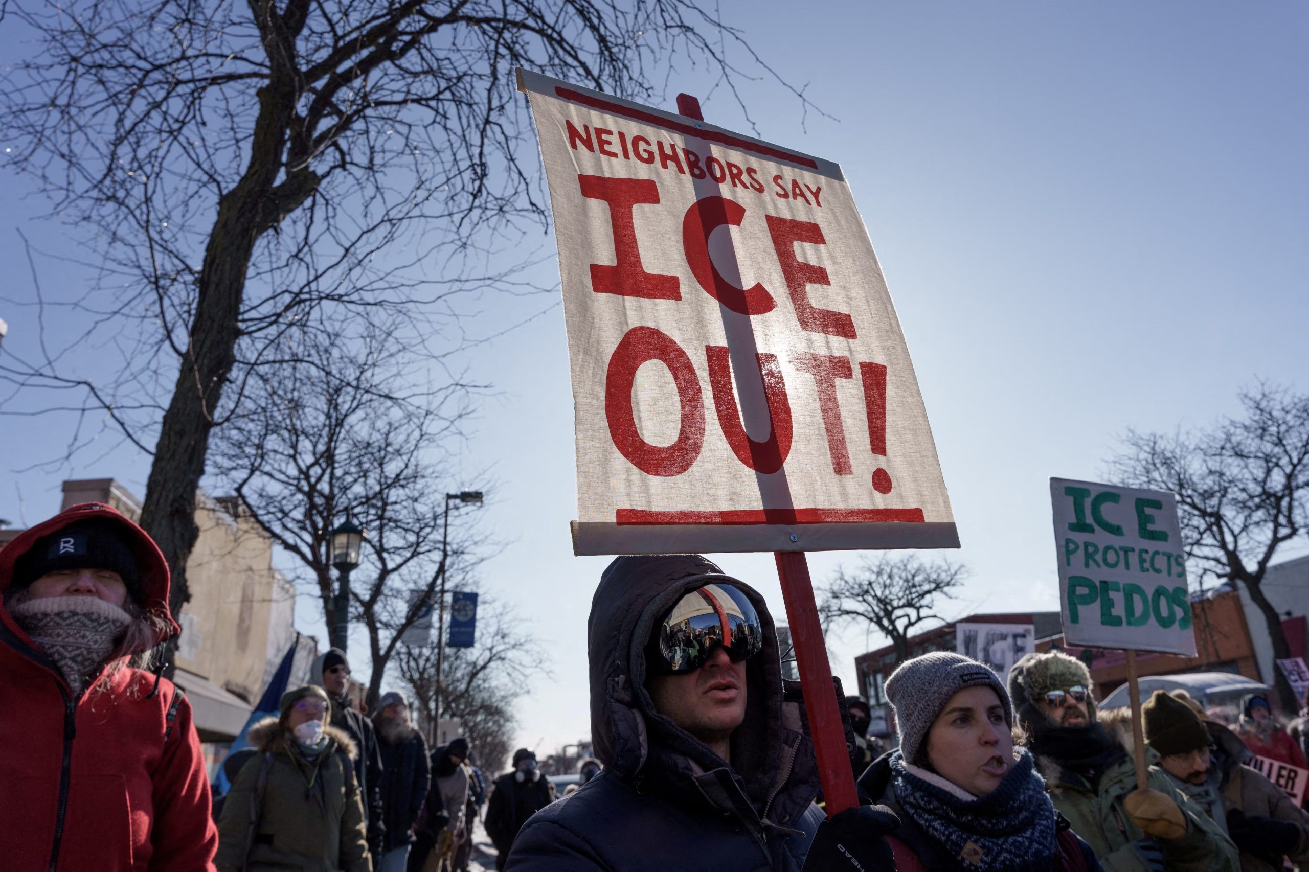 Manifestantes portan pancartas condenando al Servicio de Inmigración y Control de Aduanas (ICE) cerca del lugar donde un hombre identificado como Alex Pretti recibió un disparo mortal por parte de agentes federales que intentaban detenerlo, en Mineápolis, Minnesota, Estados Unidos. 24 de enero de 2026. REUTERS/Tim Evans/Archivo