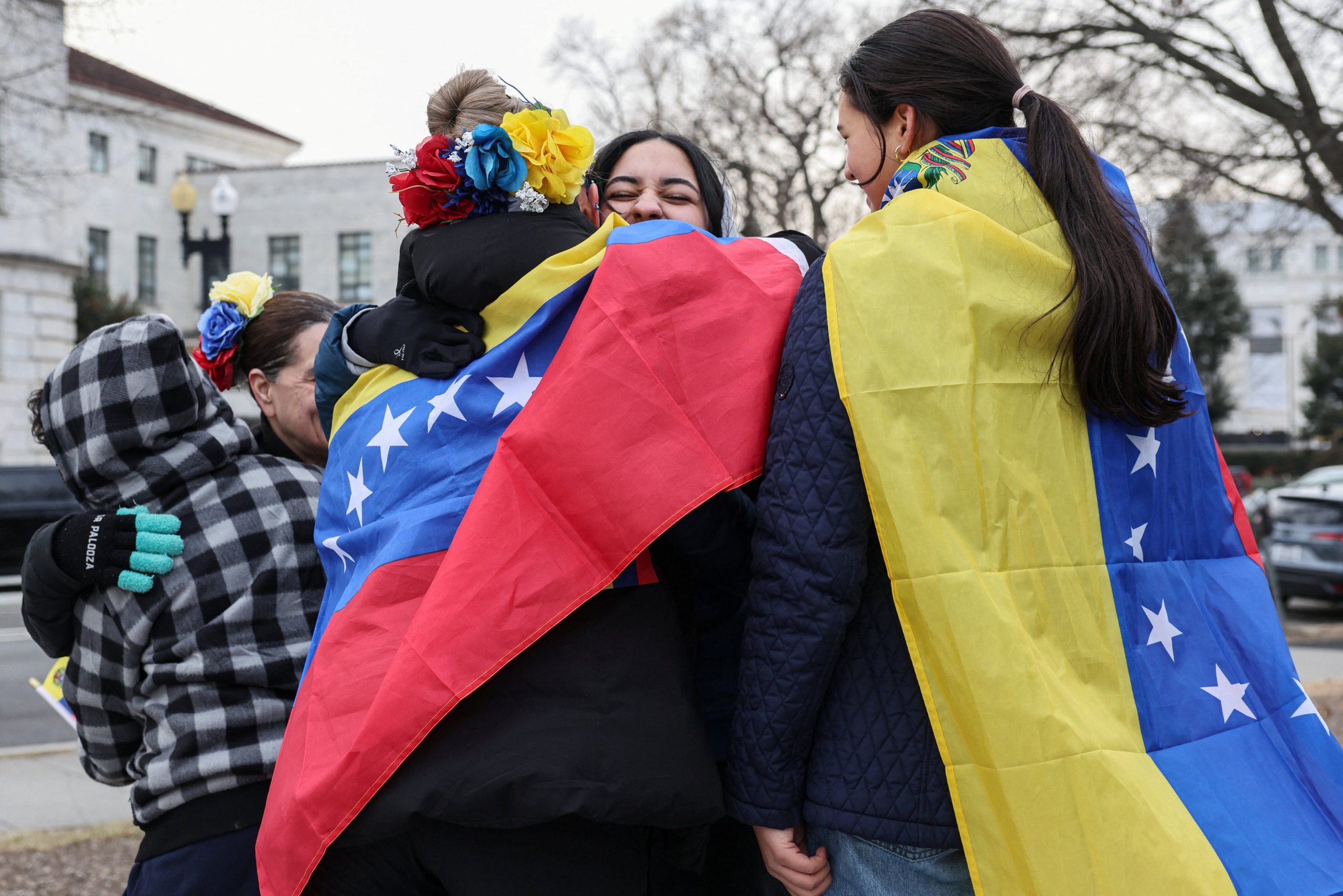 Demonstrators hug each other to celebrate after U.S. President Donald Trump said the U.S. has struck Venezuela and captured its President Nicolas Maduro and his wife Cilia Flores, in Washington, D.C., U.S., January 3, 2026. REUTERS/Tyrone Siu