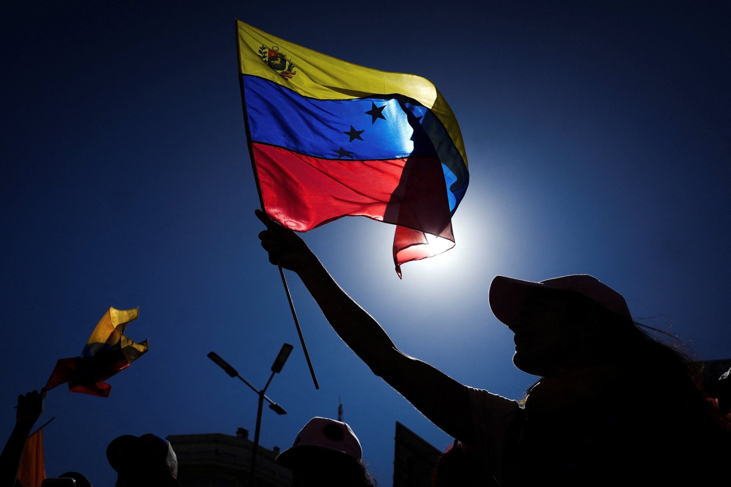 A woman waves a flag as people gather at the Obelisk to celebrate following a U.S. strike on Venezuela where President Nicolas Maduro and his wife, Cilia Flores, were captured, in Buenos Aires, Argentina January 3, 2026. REUTERS/Mariana Nedelcu