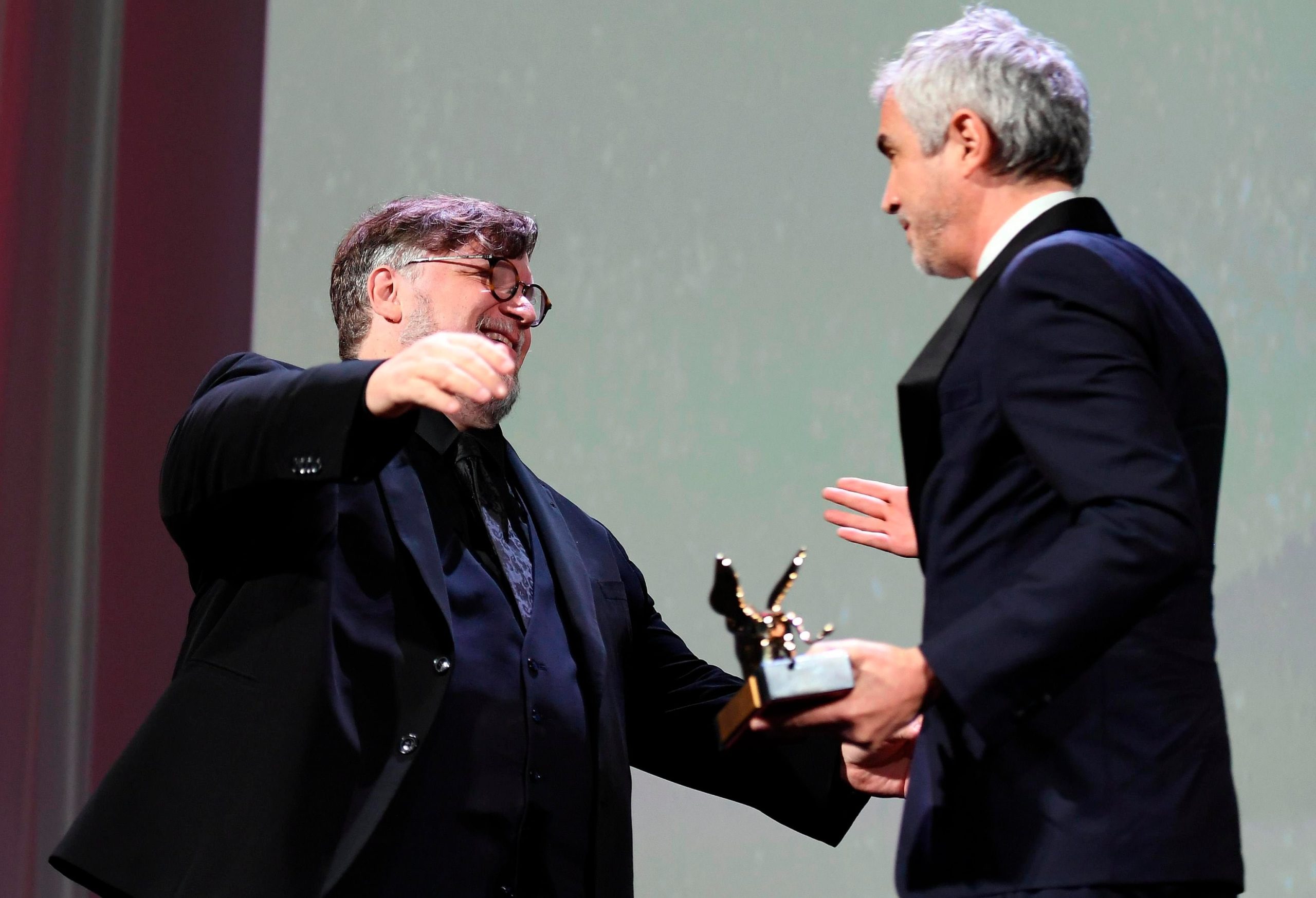 El cineasta mexicano Alfonso Cuarón (der.) abraza al director mexicano Guillermo Del Toro (izq.) luego de recibir el León de Oro por su película 'Roma' durante la ceremonia de entrega del 75 ° Festival Internacional de Cine de Venecia. EFE/EPA/Claudio Onorati/Archivo
