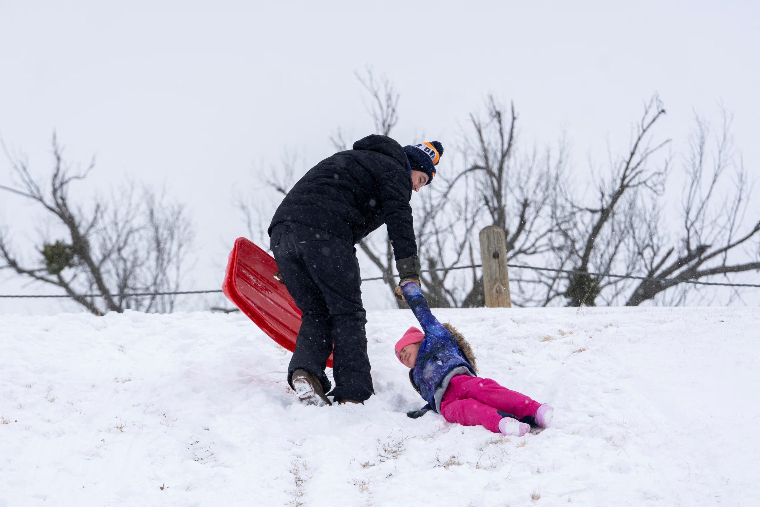 JP Ritchie ayuda a su hija Charlotte Ritchie mientras se resbala en una colina para trineos durante la tormenta invernal Fern en Oklahoma City, Oklahoma, EE. UU., el 24 de enero de 2026. REUTERS/Nick Oxford