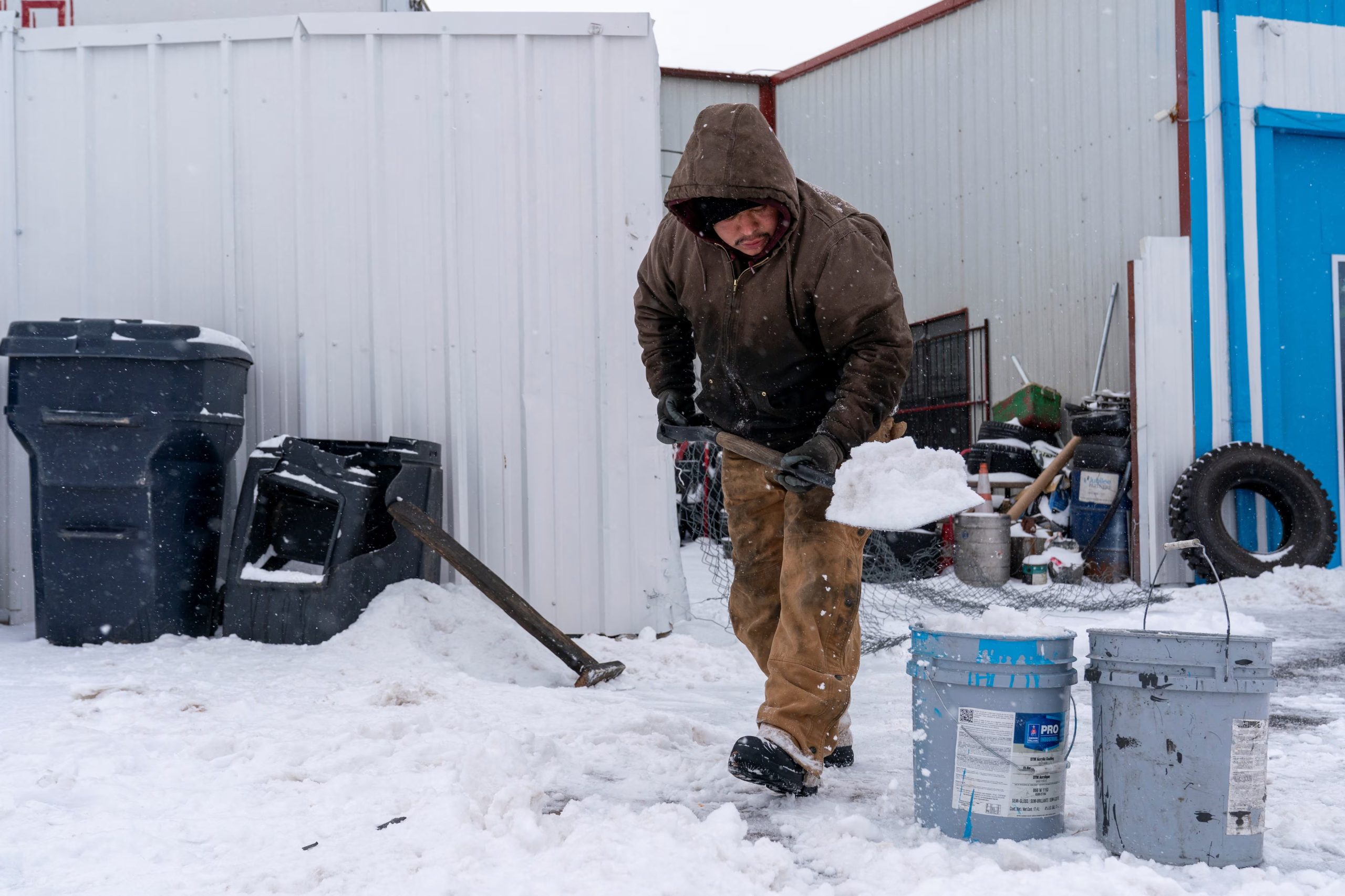 Un hombre limpia el estacionamiento del taller de neumáticos donde trabaja durante la tormenta invernal Fern en Oklahoma City, Oklahoma, EE. UU., el 24 de enero de 2026. REUTERS/Nick Oxford