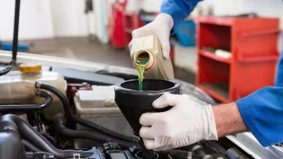 Cambio de aceite del motor de un coche en un taller mecánico. (SIGAUS)