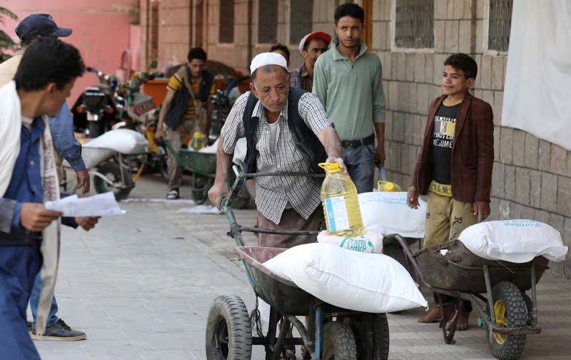 Trabajadores transportan ayuda alimentaria para beneficiarios del Programa Mundial de Alimentos en un centro de distribución, en medio de una escasez exacerbada de alimentos, en Sanaa, Yemen. REUTERS