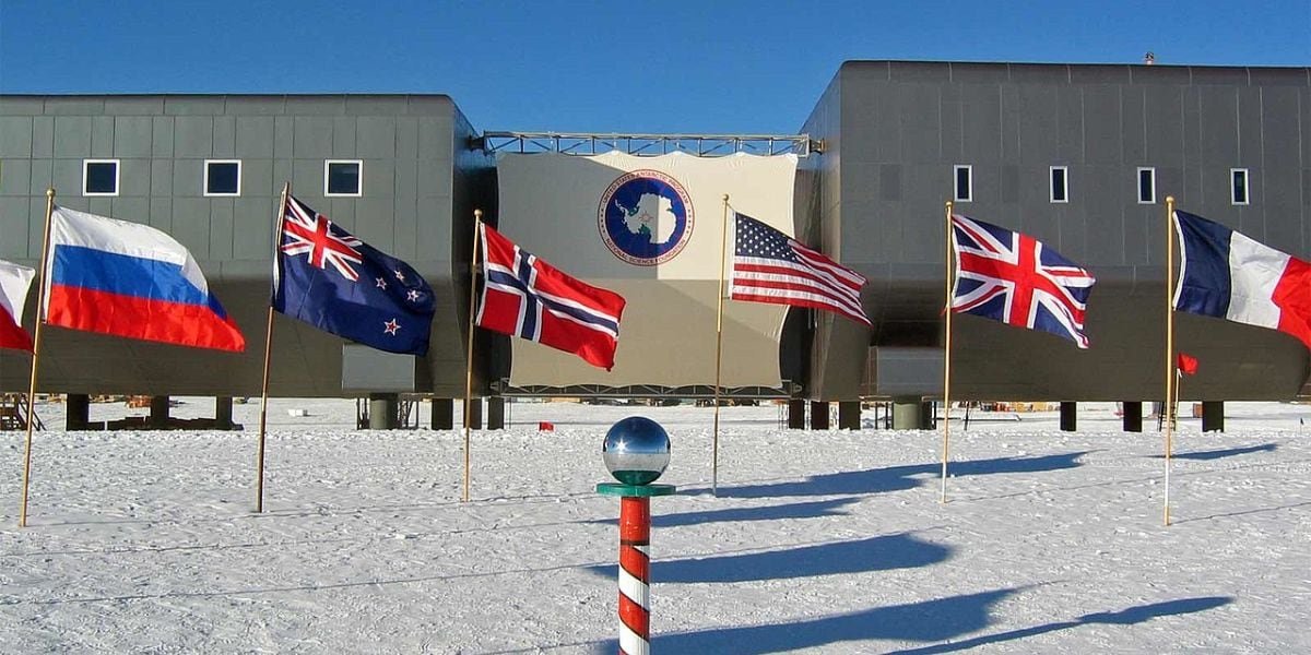 Estación Amundsen-Scott ubicada en el Polo Sur geográfico, junto a ella, las banderas de los países del Tratado Antártico (Wikipedia)