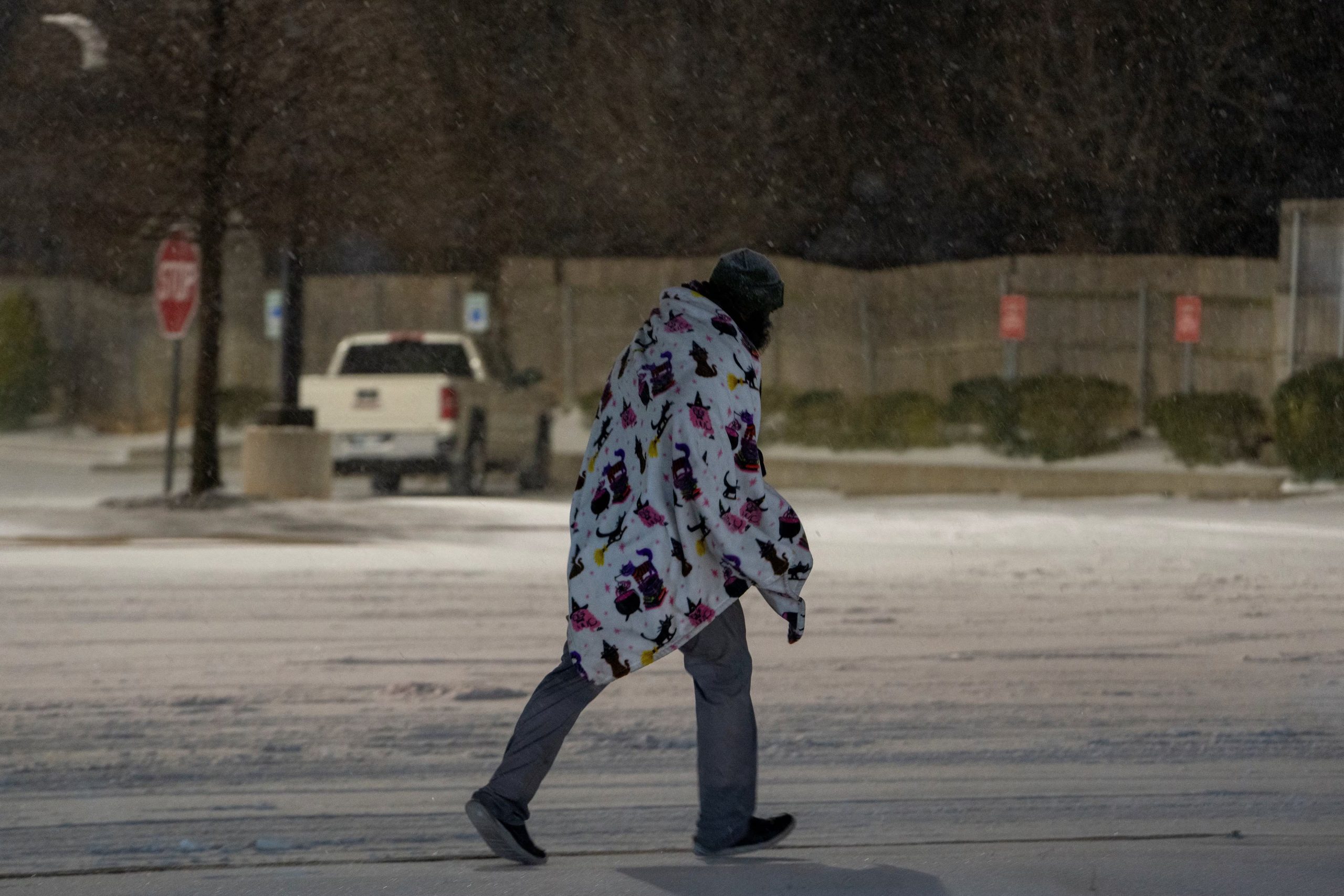 Un hombre cruza una calle con una manta encima en Oklahoma (REUTERS/Nick Oxford)