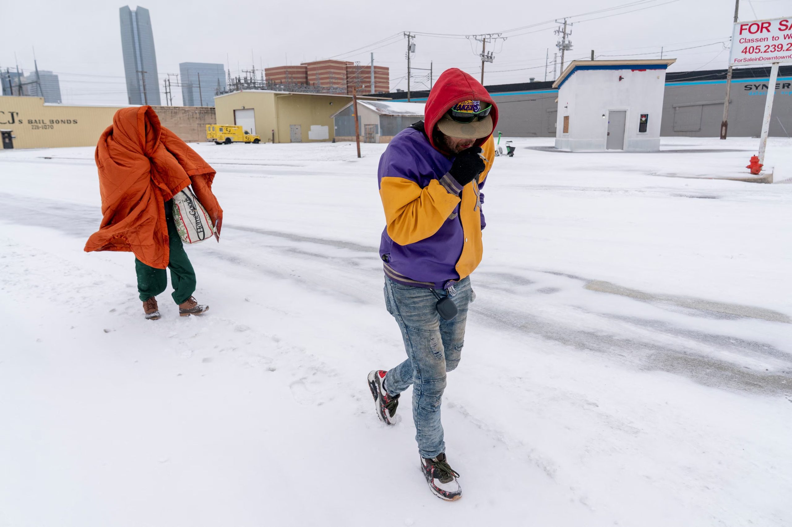 Shannon White y JP Davis, ambos en situación de calle, caminan hacia un refugio durante la tormenta invernal Fern en Oklahoma City, Oklahoma, EE. UU., el 24 de enero de 2026 (REUTERS/Nick Oxford)