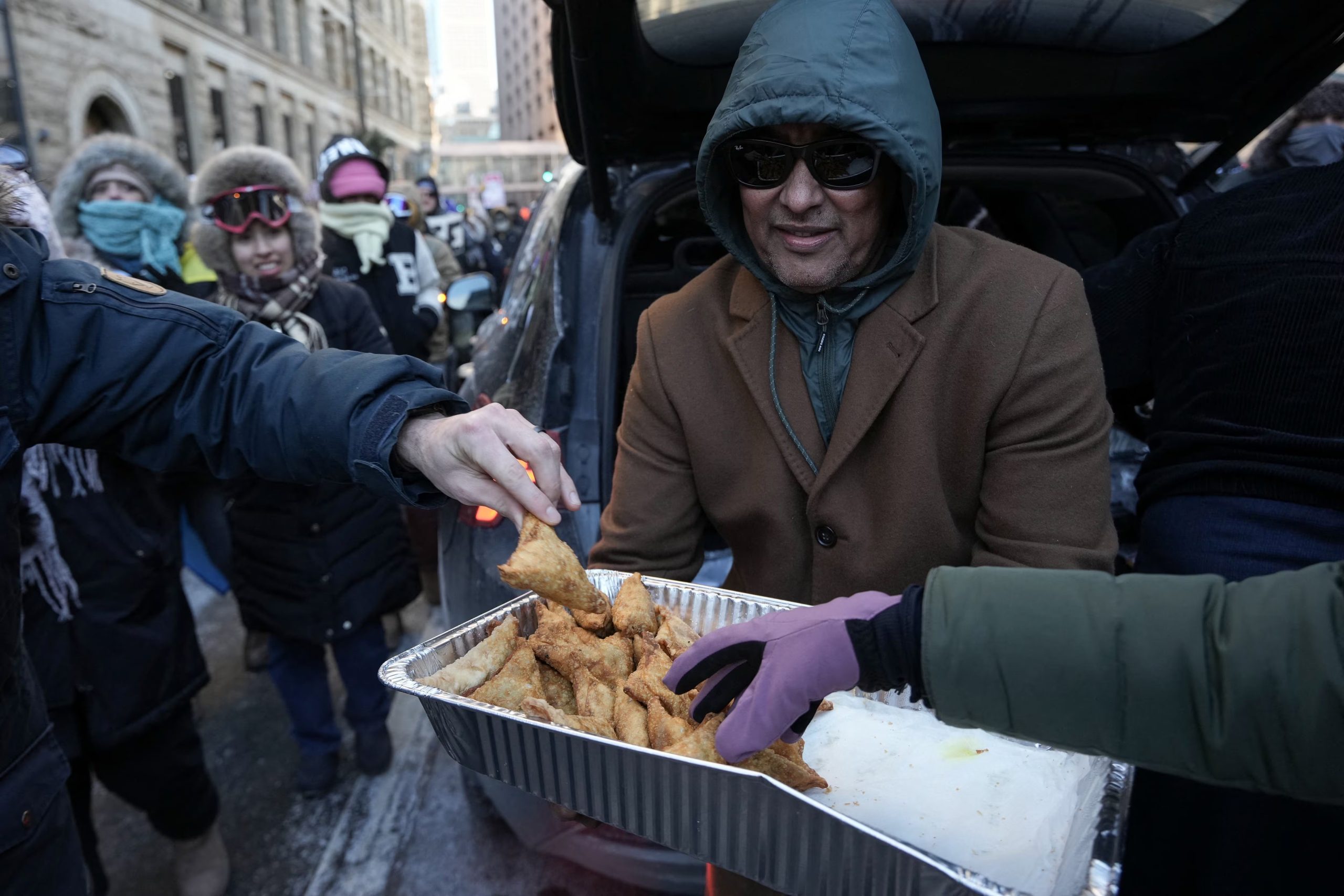 Un hombre reparte comida en medio de la protesta contra Trump y la política migratoria en Minnesota (REUTERS)