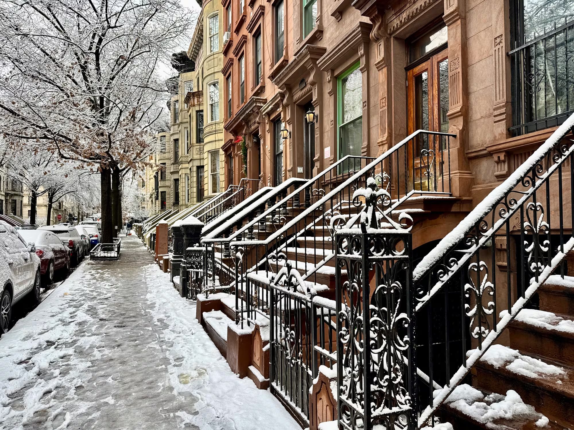 Escaleras y accesos a edificios residenciales permanecen cubiertos de nieve en un barrio de Nueva York, reflejando el impacto del clima en la rutina urbana.