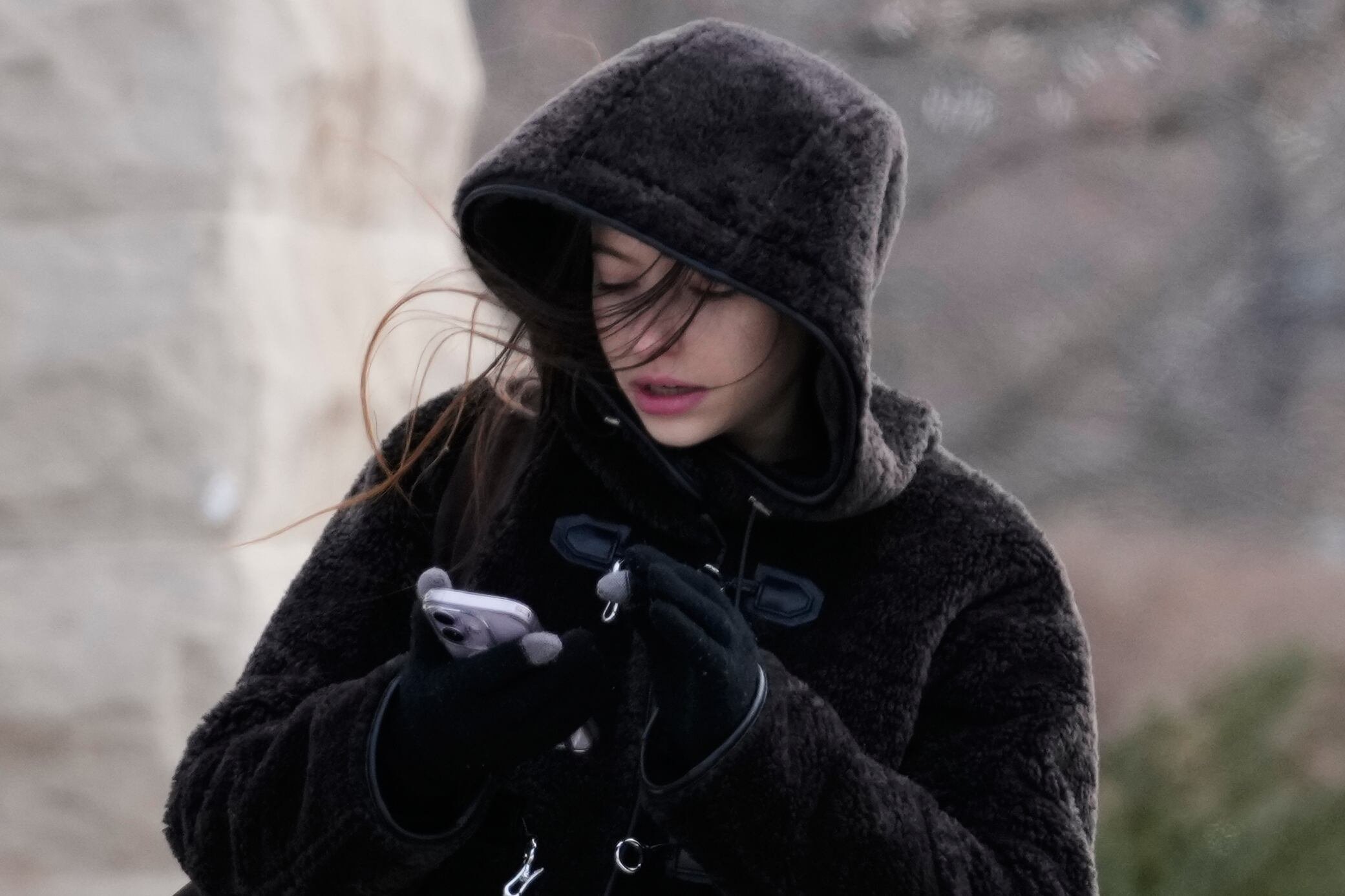 Una chica intenta manipular el celular con guantes en medio de la tormenta de frío en Evanston (AP Photo/Nam Y. Huh)