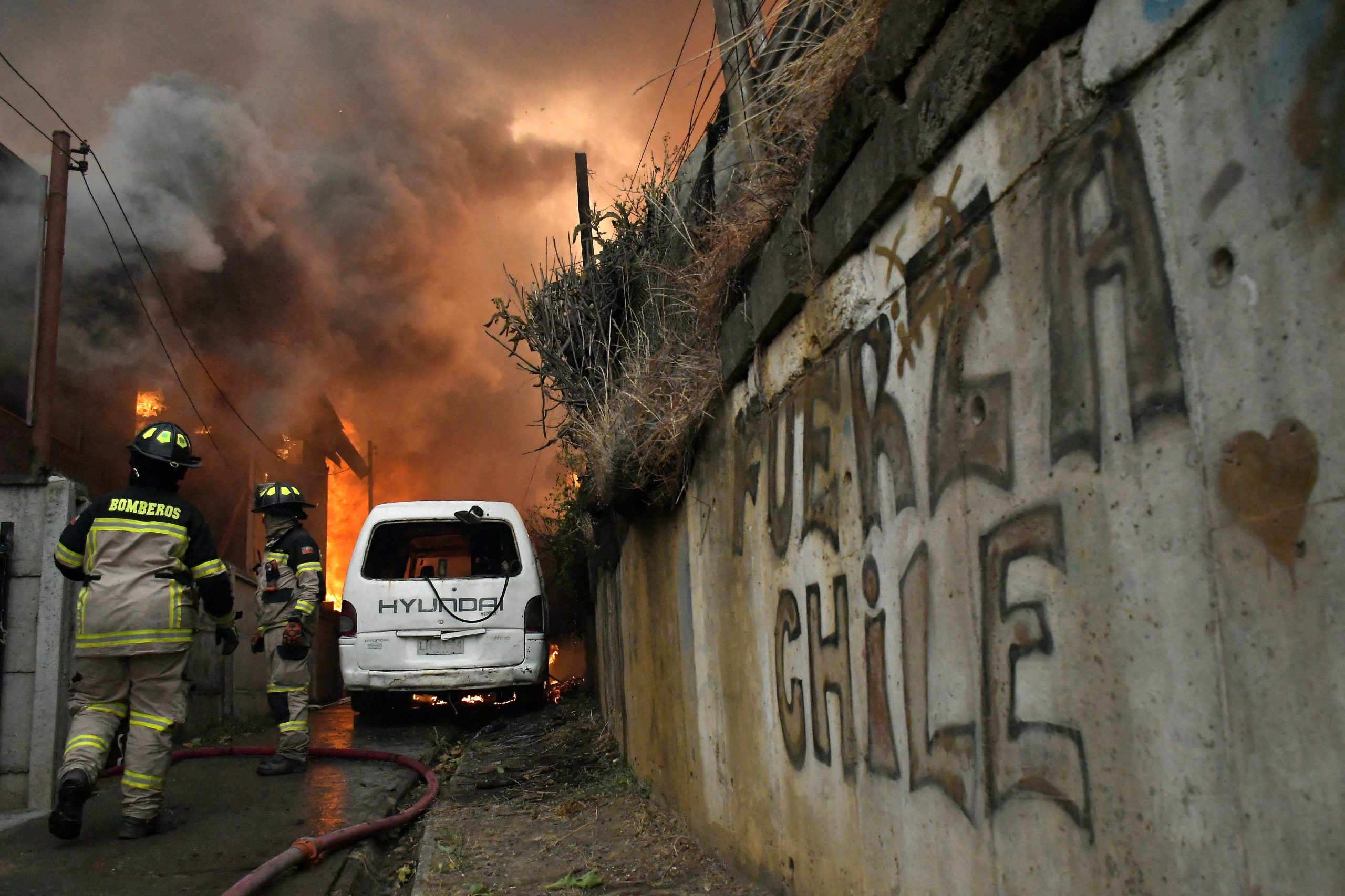 Bomberos combaten las llamas que consumen una casa en Concepción (GUILLERMO SALGADO / AFP)