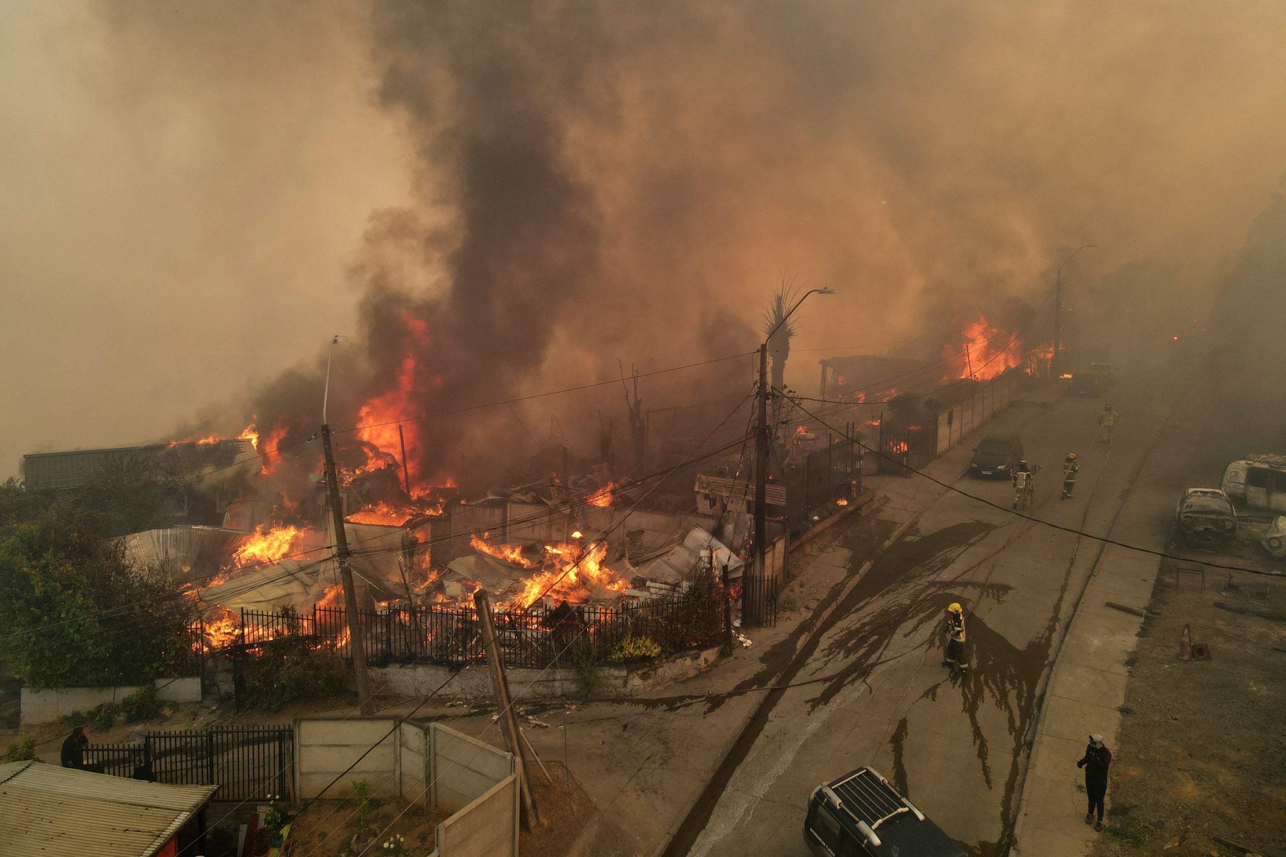 Vista aérea de viviendas envueltas en humo y llamas durante un incendio forestal en Concepción (GUILLERMO SALGADO / AFP)