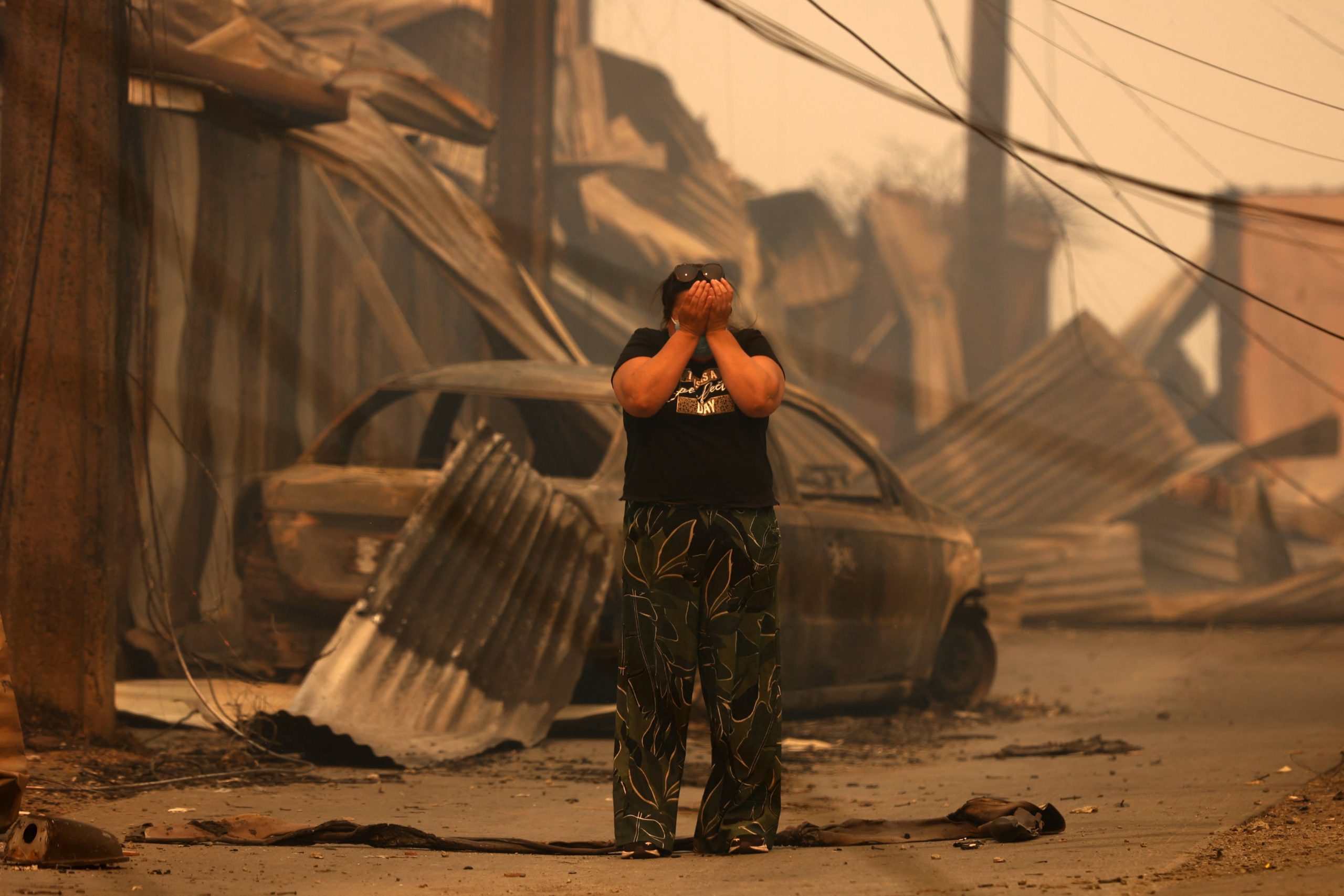 Una habitante de Concepción reacciona ante las viviendas y vehículos destruidos tras los incendios forestales (RAÚL BRAVO / AFP)