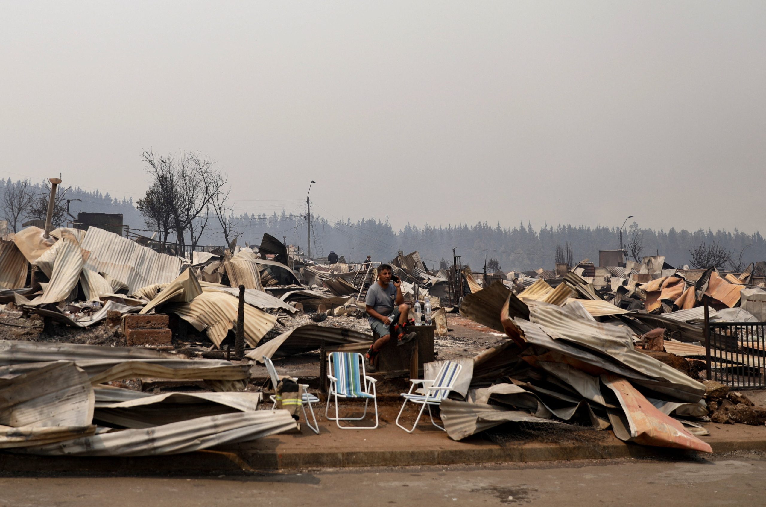 Residentes afectados por los incendios forestales intentan comunicarse mientras revisan los daños en sus viviendas (REUTERS/Juan Gonzalez)
