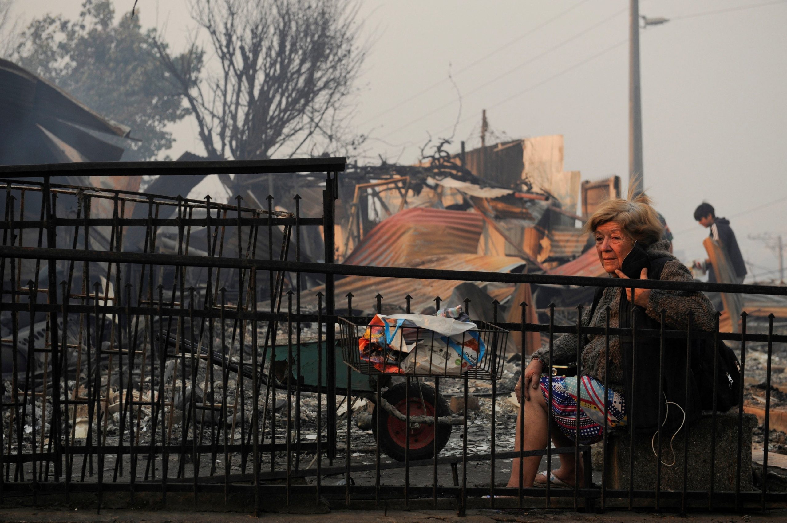 Tras los incendios forestales, una habitante se sienta entre los restos de un edificio afectado en Lirquén, sur de Chil (REUTERS/Jose Luis Saavedra)
