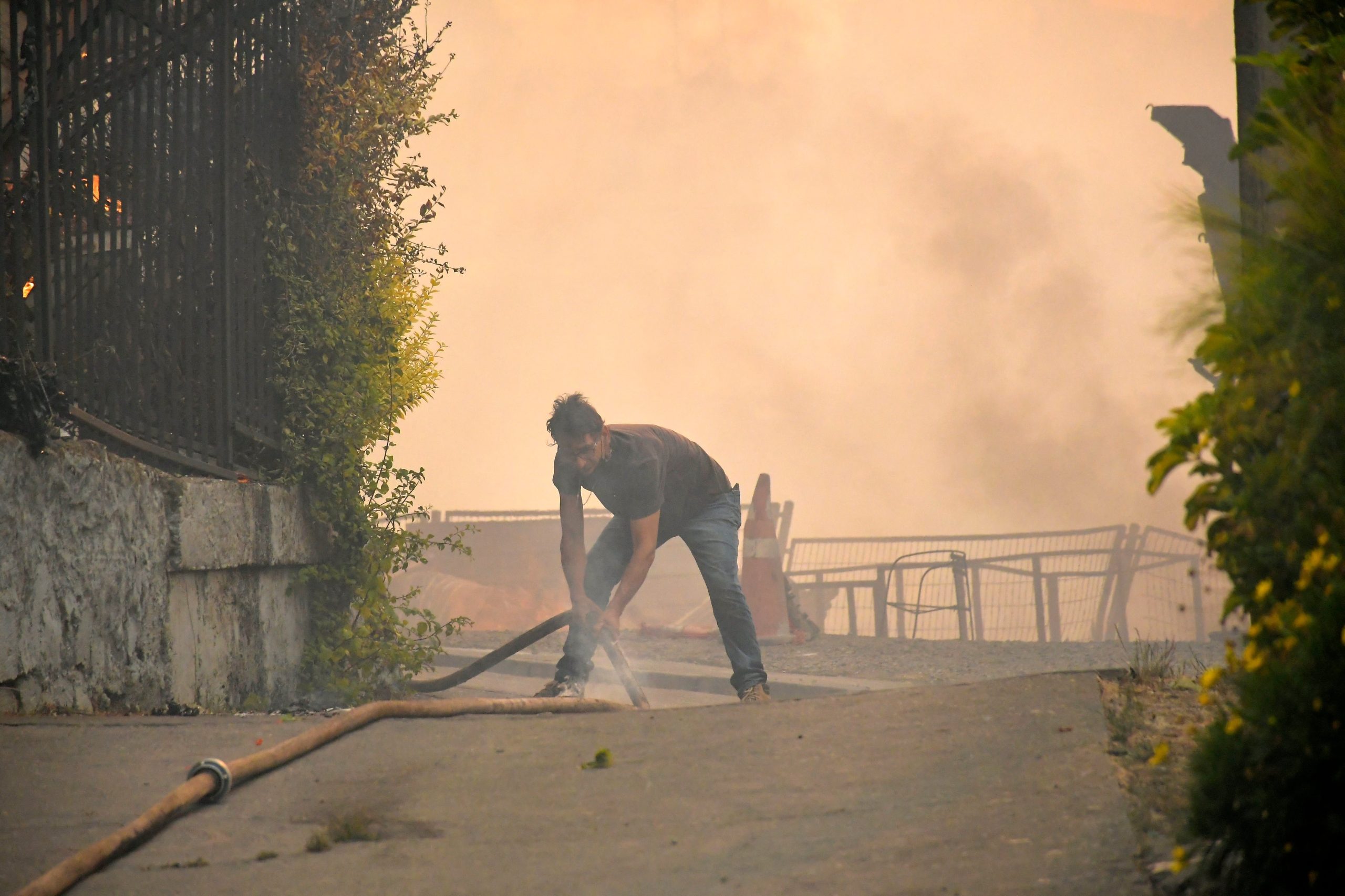 Un vecino combate el fuego que consume una casa en Concepción, en medio de los incendios forestales que obligaron a miles de personas a evacuar (GUILLERMO SALGADO / AFP)