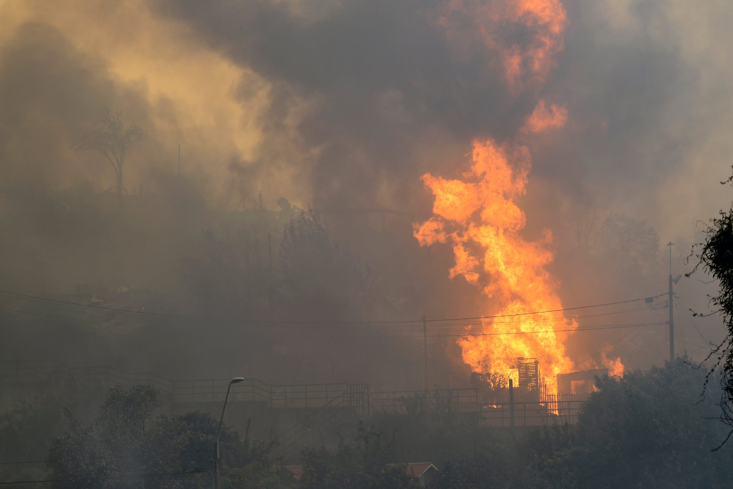 El fuego consume una casa en Concepción, una de las zonas afectadas por los incendios forestales que llevaron a declarar el estado de emergencia (GUILLERMO SALGADO / AFP)