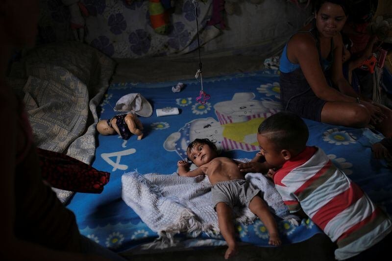 Gregoria Hernández, 23, junto a su hija de siete meses Sonia, quien dijo que tiene diarrea y está por debajo de su peso, mientras está en su cama en Barquisimeto, Venezuela, 16 de agosto de 2019. Según la última Encuesta Nacional de Condiciones de Vida, el 86.9% de la población venezolana vive en situación de pobreza. (REUTERS/Carlos Garcia Rawlins)
