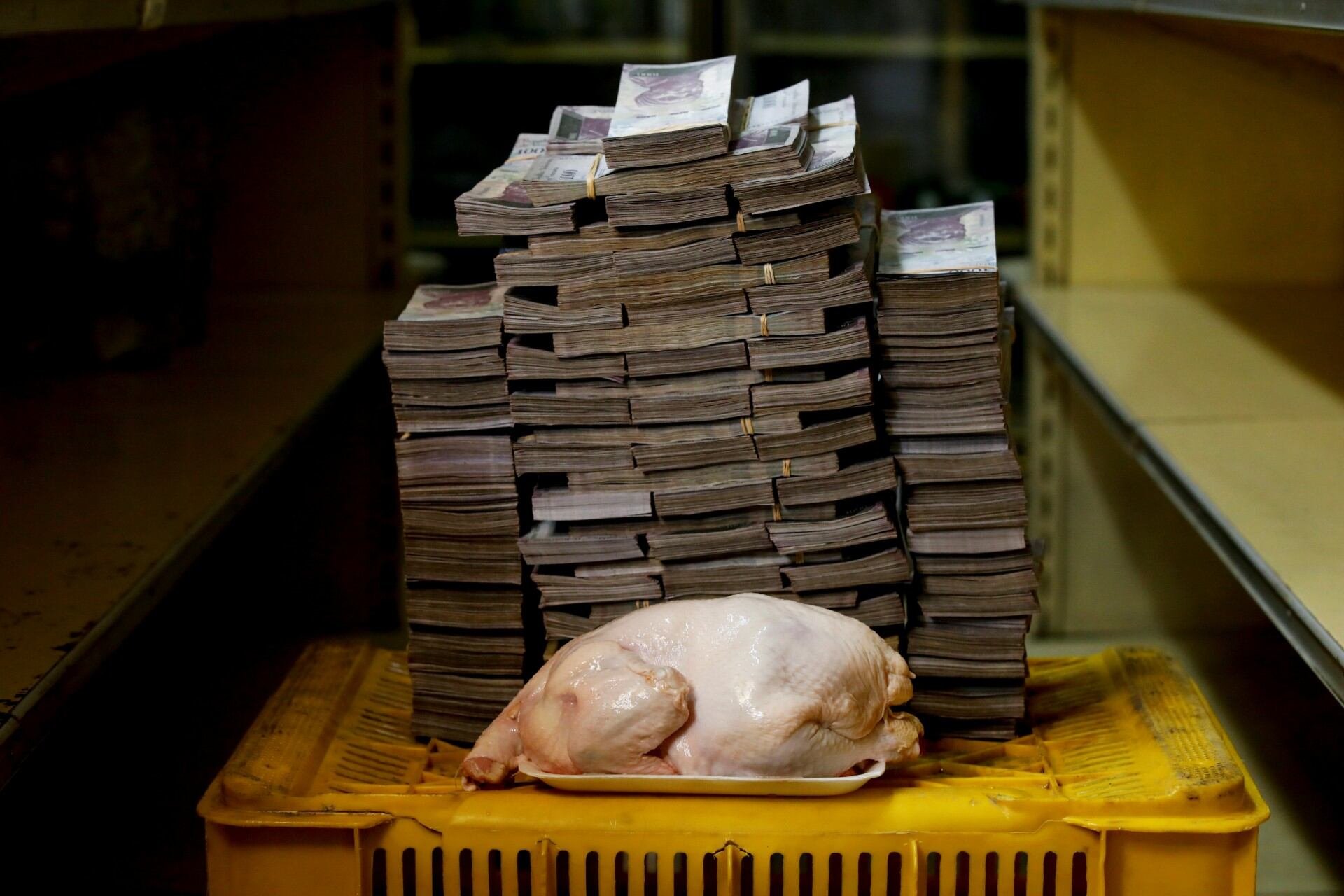 Un pollo de 2.4 kg junto a 14,600,000 bolívares, su precio equivalente a 2.22 dólares, en un mini-mercado de Caracas, Venezuela, 16 de agosto de 2018. La inflación acumulada entre 2013 y 2019 superó los 5,395 millones por ciento, obligando a los venezolanos a pesar el dinero en vez de contarlo. (REUTERS/Carlos Garcia Rawlins)