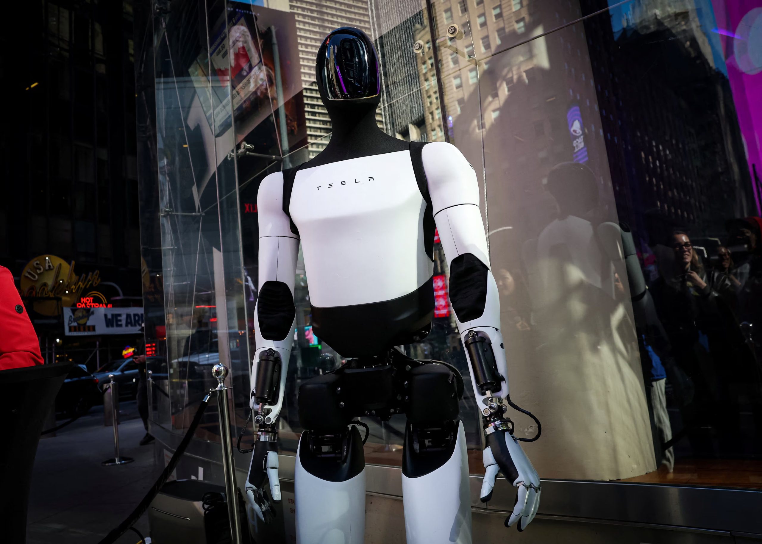 A crowd watches and interacts with a Tesla Optimus robot outside the Nasdaq Market site in New York City, U.S., October 27, 2025. REUTERS/Brendan McDermid