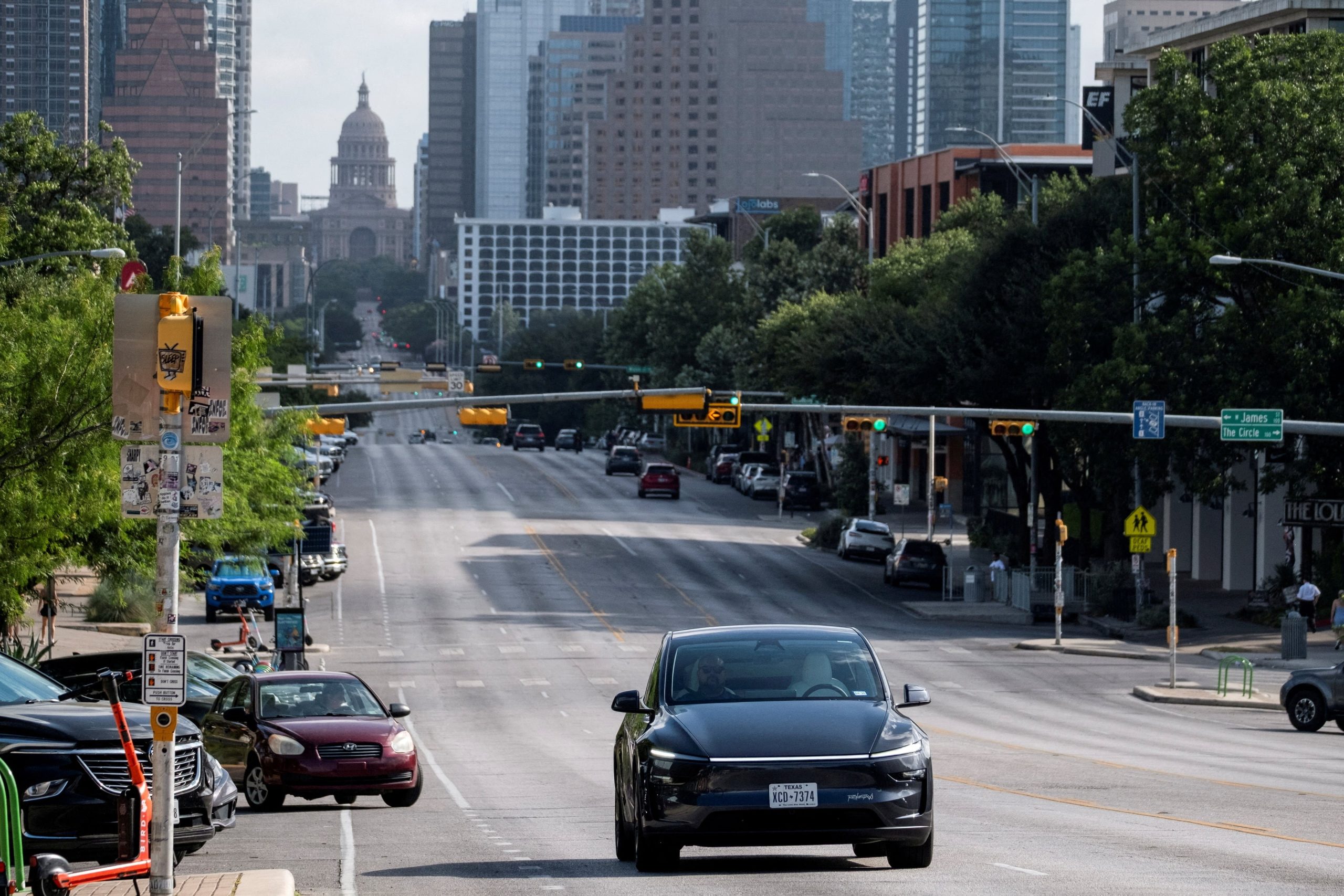 FILE PHOTO: A Tesla robotaxi drives on the street along South Congress Avenue in Austin, Texas, U.S., June 22, 2025. REUTERS/Joel Angel Juarez/File Photo