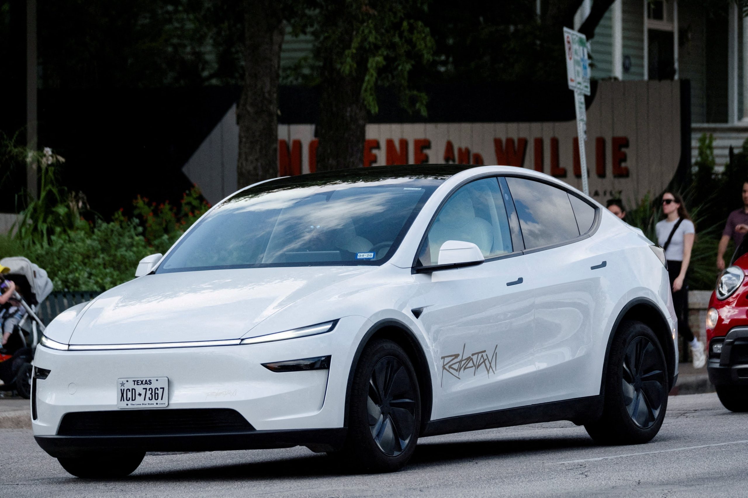 FILE PHOTO: FILE PHOTO: A Tesla robotaxi drives on the street along South Congress Avenue in Austin, Texas, U.S., June 22, 2025. REUTERS/Joel Angel Juarez/File Photo/File Photo