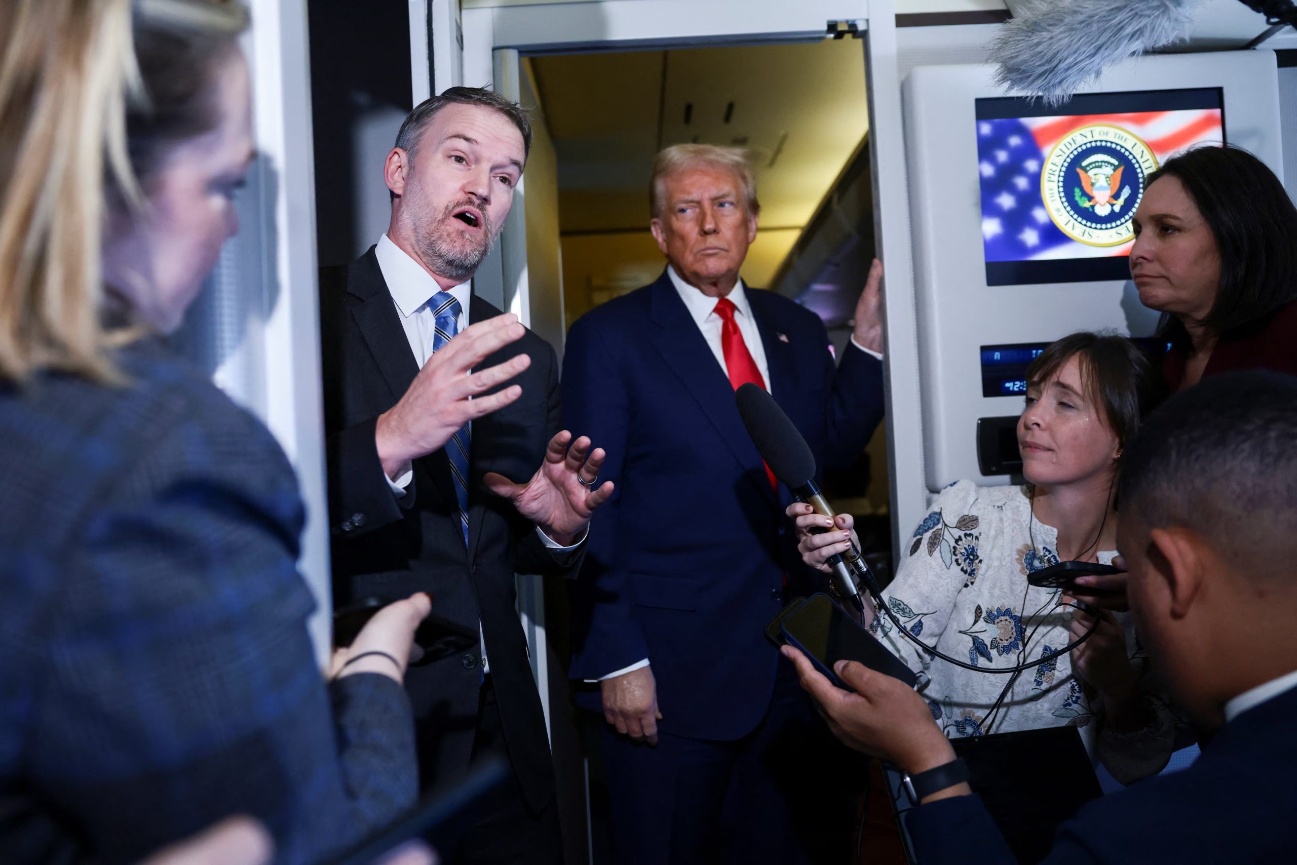 El presidente de Estados Unidos, Donald Trump, observa mientras el representante comercial de Estados Unidos, Jamieson Greer, habla con miembros de los medios a bordo del Air Force One (REUTERS/Evelyn Hockstein/Archivo)