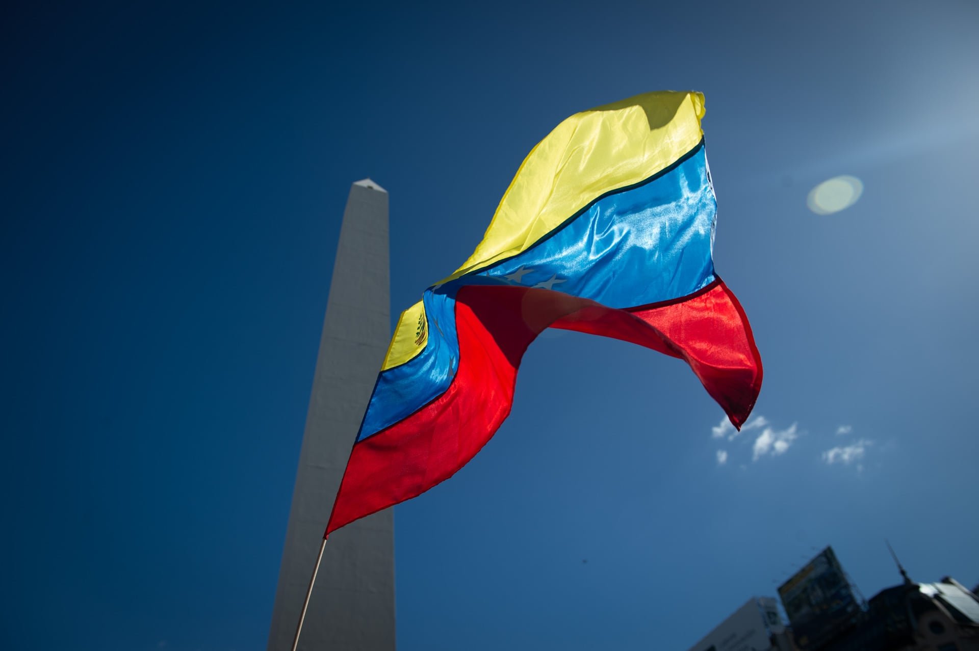 Una bandera venezolana flamea frente al Obelisco