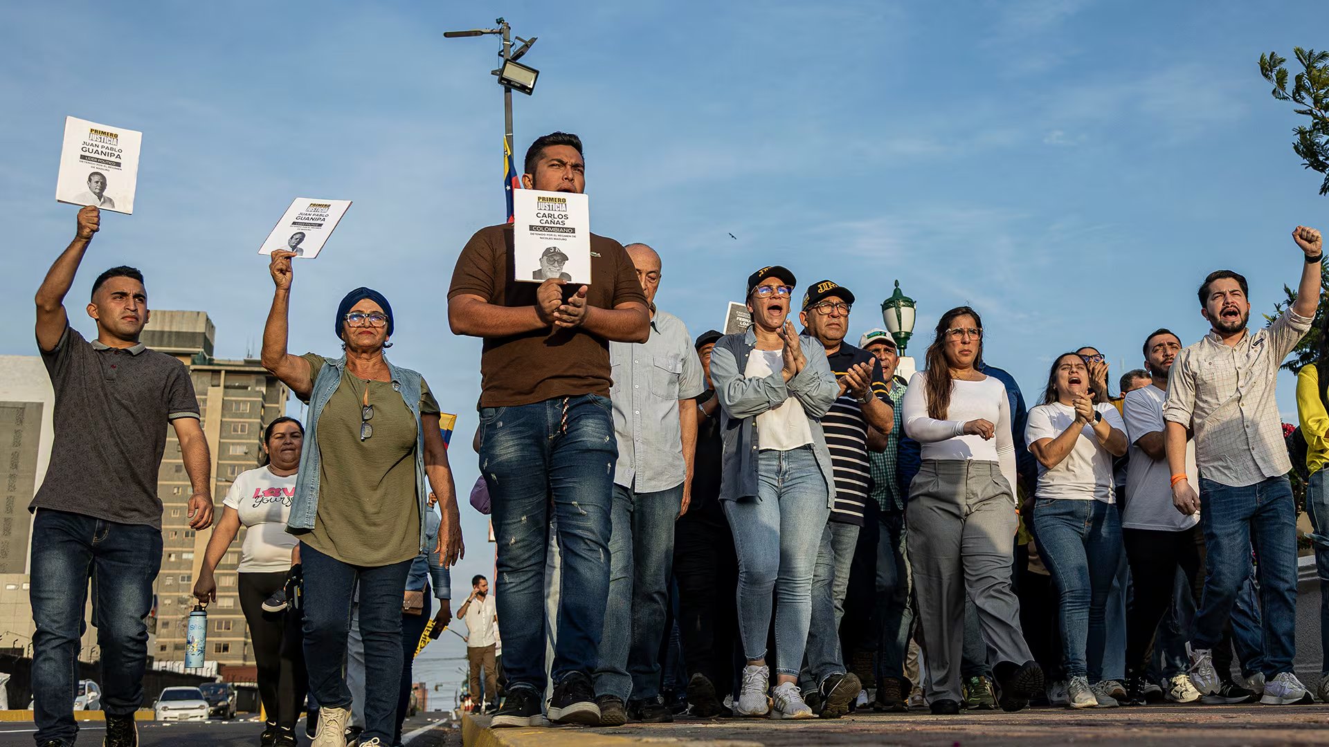Personas sostienen carteles durante una manifestación por la libertad de los presos políticos y del opositor Juan Pablo Guanipa (EFE/Henry Chirinos)