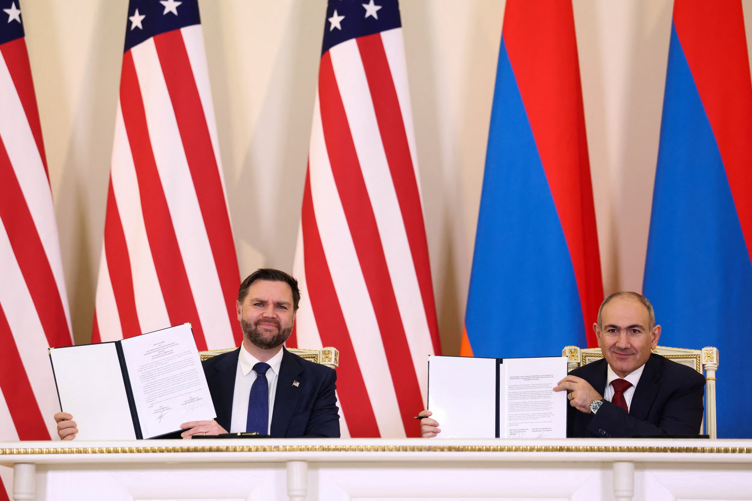 El vicepresidente de Estados Unidos, J. D. Vance, y el primer ministro de Armenia, Nikol Pashinyan, sostienen copias firmadas de la 