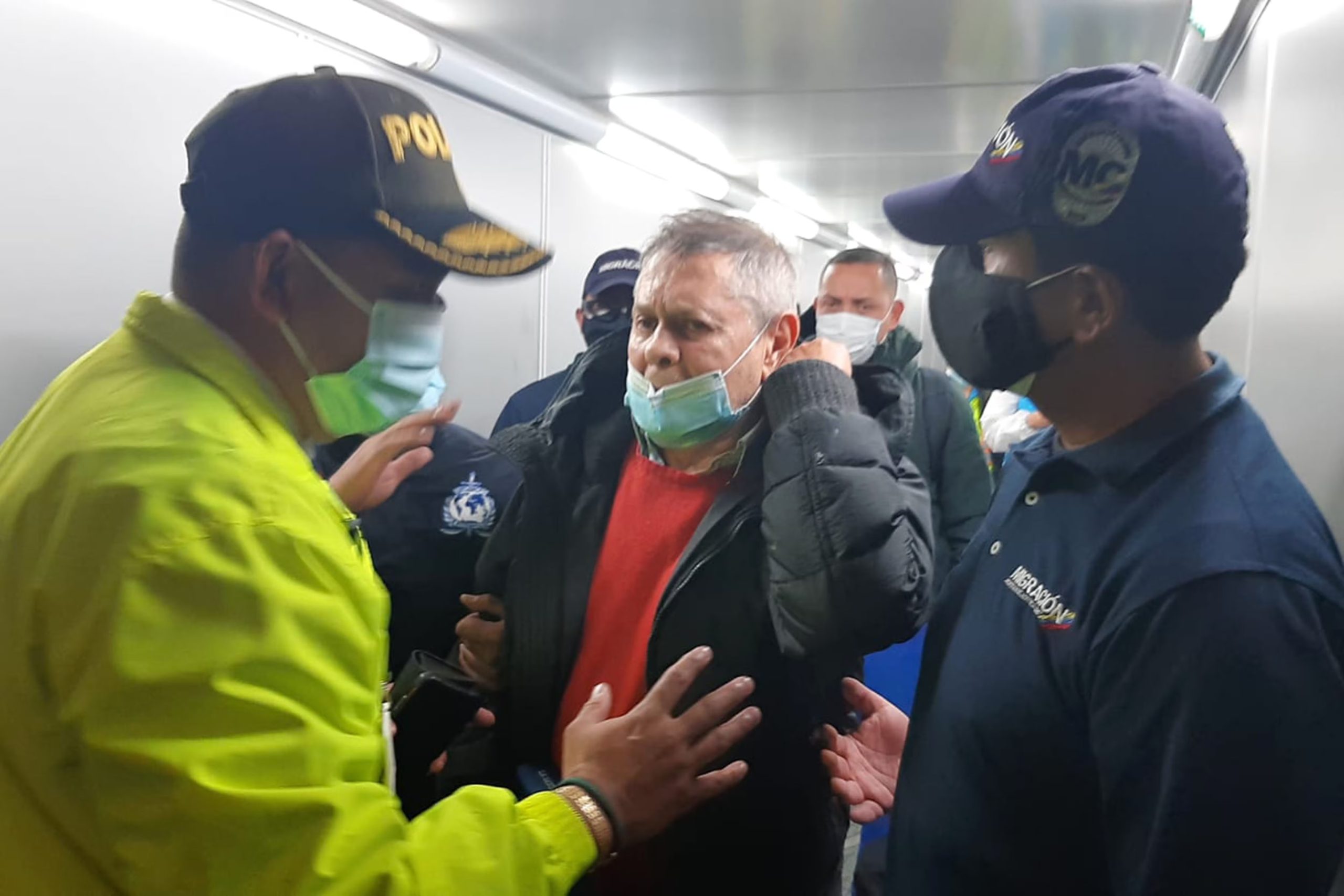 Fotografía cedida por la Policía Nacional de Colombia que muestra al empresario Carlos Mattos (c) mientras es acompañado por oficiales de la Policía colombiana y Migración Colombia durante su llegada al aeropuerto El Dorado de Bogotá (Colombia) en 2022 - crédito EFE