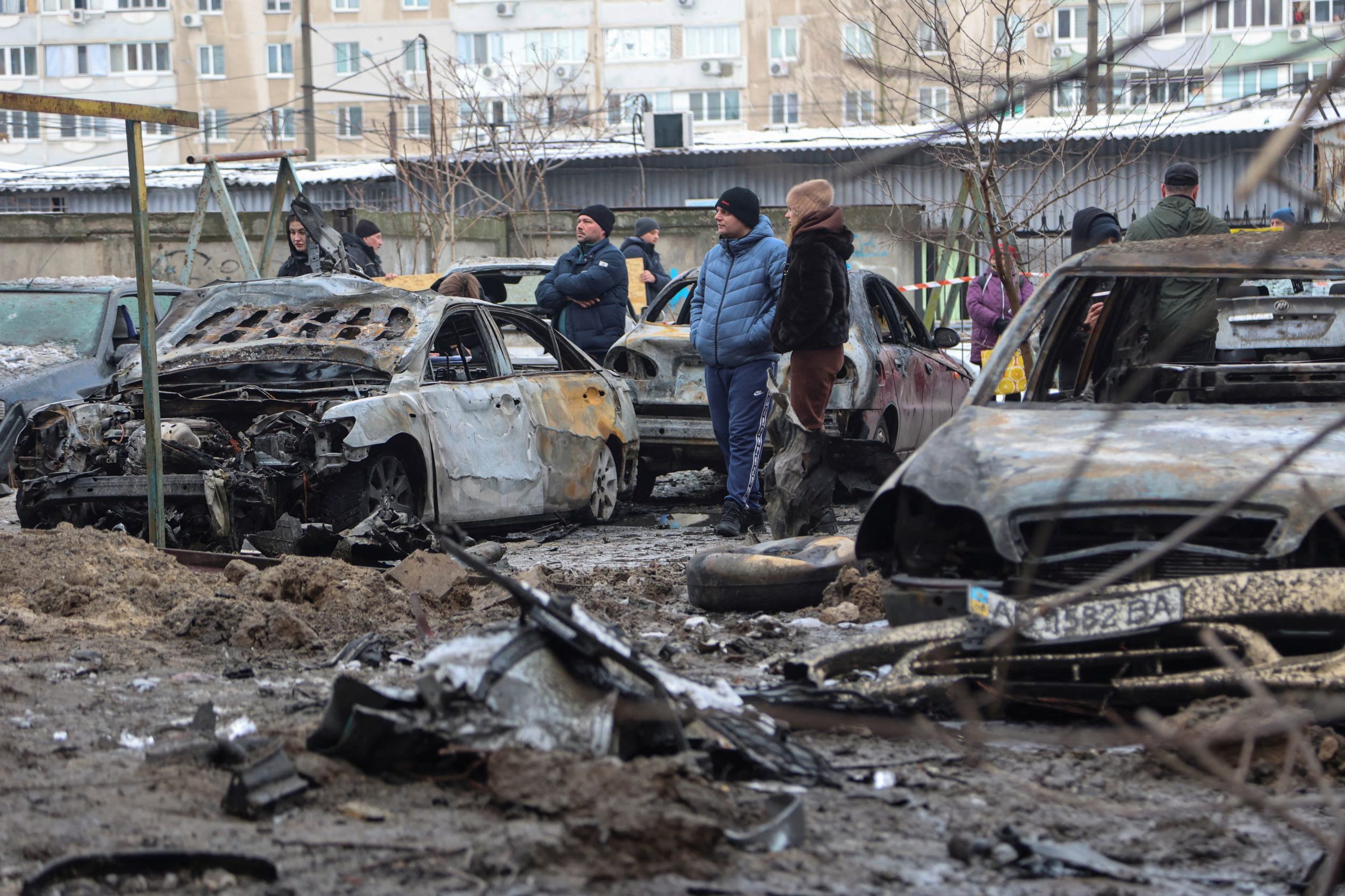 Residentes junto a autos quemados en el lugar de un edificio de apartamentos dañado durante los ataques nocturnos con drones y misiles rusos, en medio del ataque de Rusia a Ucrania, en Zaporizhia. REUTERS/Serhii Chalyi/Foto de archivo