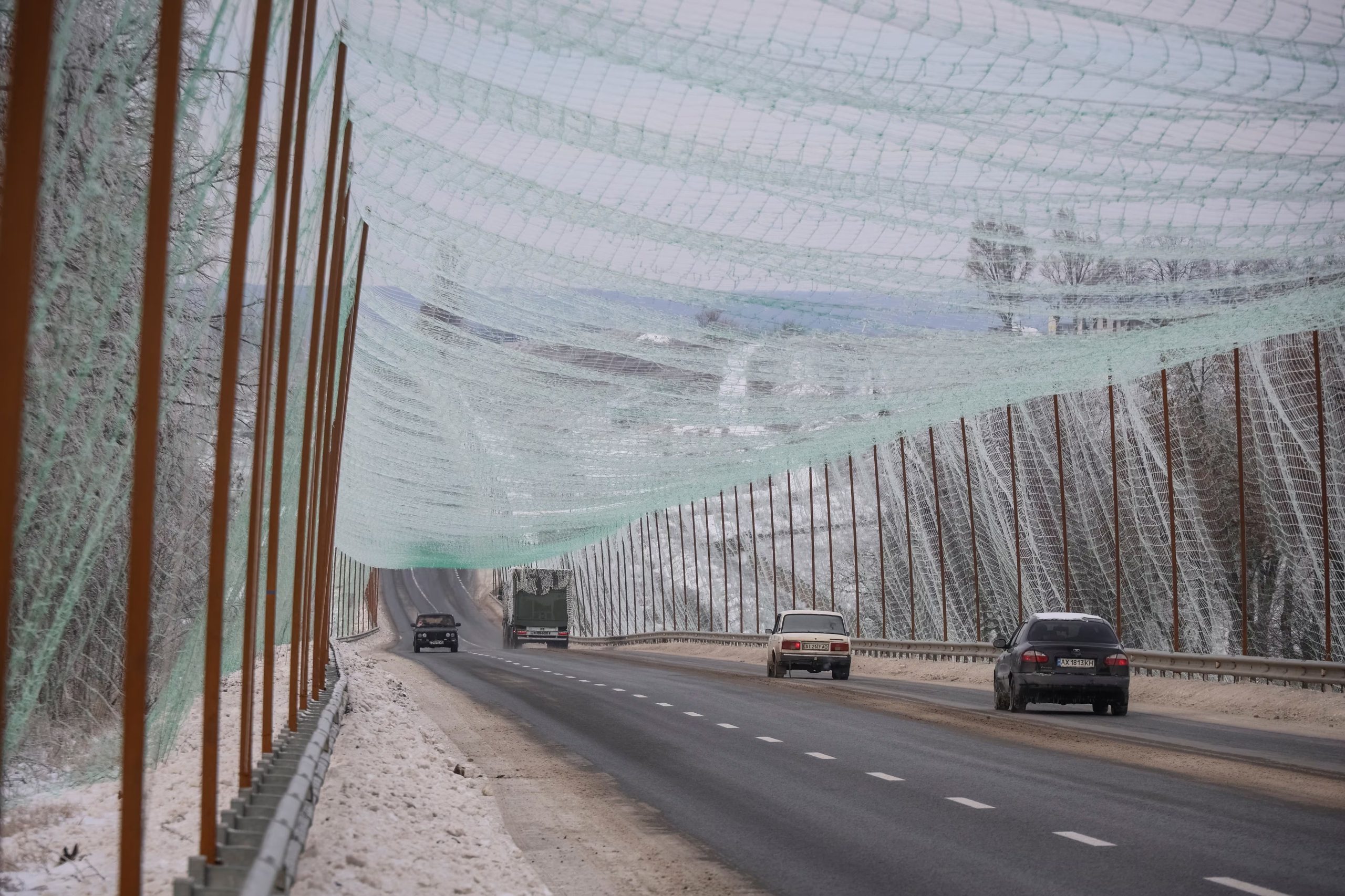 Cars drive along a road covered with an newly installed anti-drone net, amid Russia's attack on Ukraine, near Kharkiv, Ukraine February 2, 2026 (REUTERS/Vyacheslav Madiyevskyy)