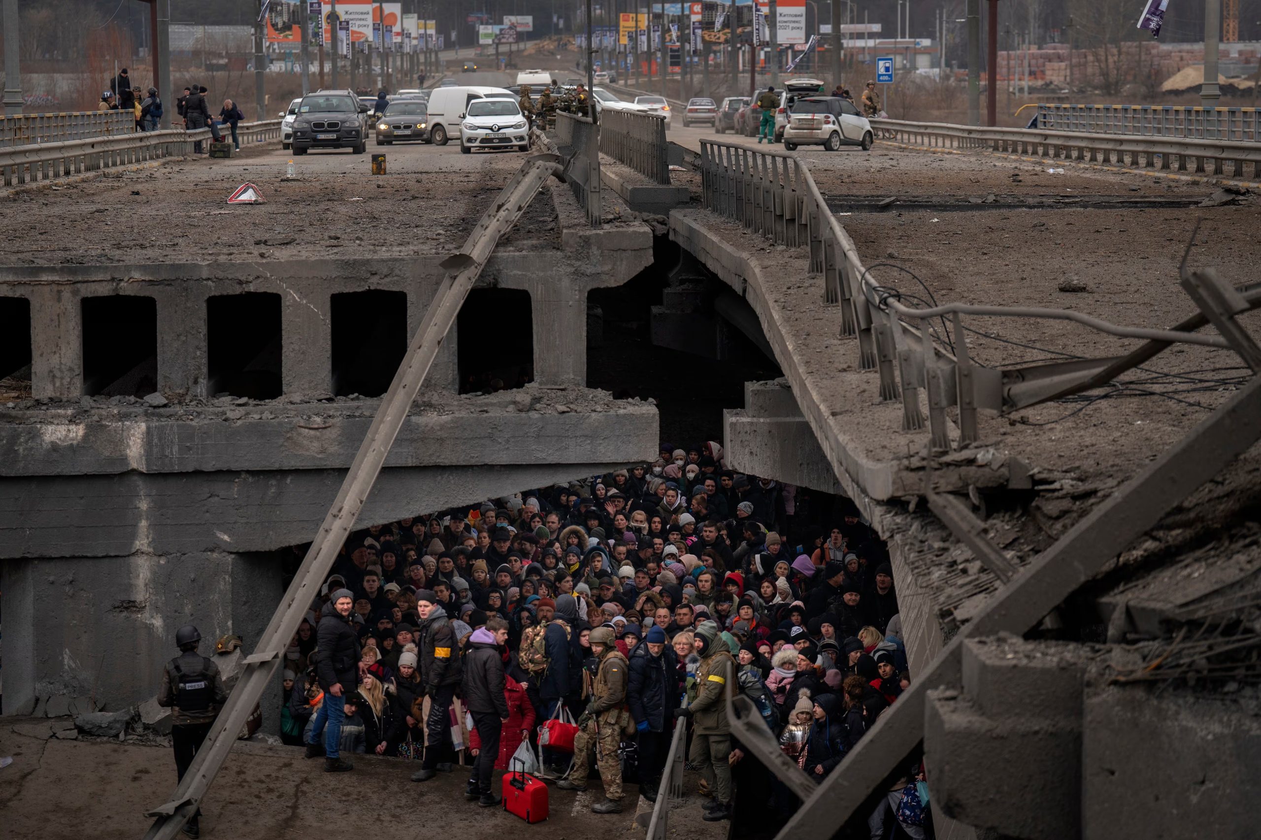 Ucranianos se agolpan bajo un puente destruido mientras intentan huir cruzando el río Irpin en las afueras de Kiev, Ucrania, el sábado 5 de marzo de 2022 (AP/Emilio Morenatti, Archivo)